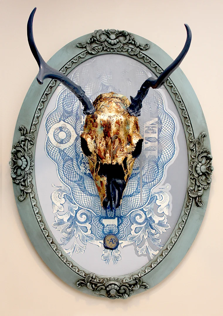 Title: SYMPOSIUM This is the second piece in the series of a new direction that Anthony is artistically heading. He is working on a unique fusion of painting, drawing and re-purposed objects. This piece features an authentic deer skull that has been hand painted and gold leafed, mounted on a hand painted acrylic/mixed media background, and framed in a hand painted antique frame. The skulls that he acquires come from humane and environmentally responsible means. Adding to the flair, is the custom made wax stamp signature you will find on each painting. Each wax stamp has it's own unique design that is specific to the year the piece was created. This piece has been professionally framed and mounted with a dust cover and installed hanging hardware. 17"W X 23"H X 12.75"D Interested in acquiring this lovely piece? Click here for purchasing info.