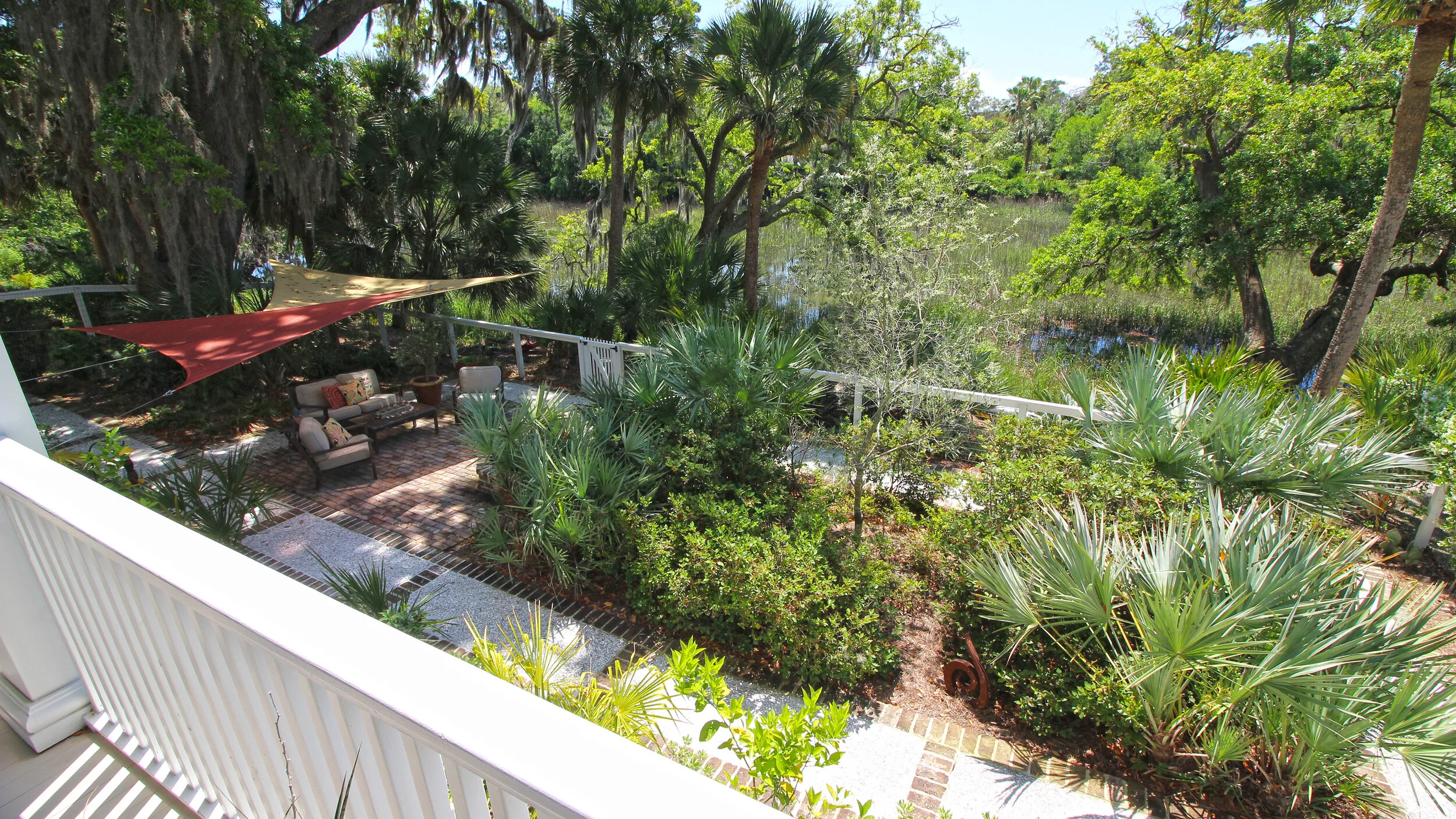  1st floor porch view overlooking marsh-side courtyard/gardens 