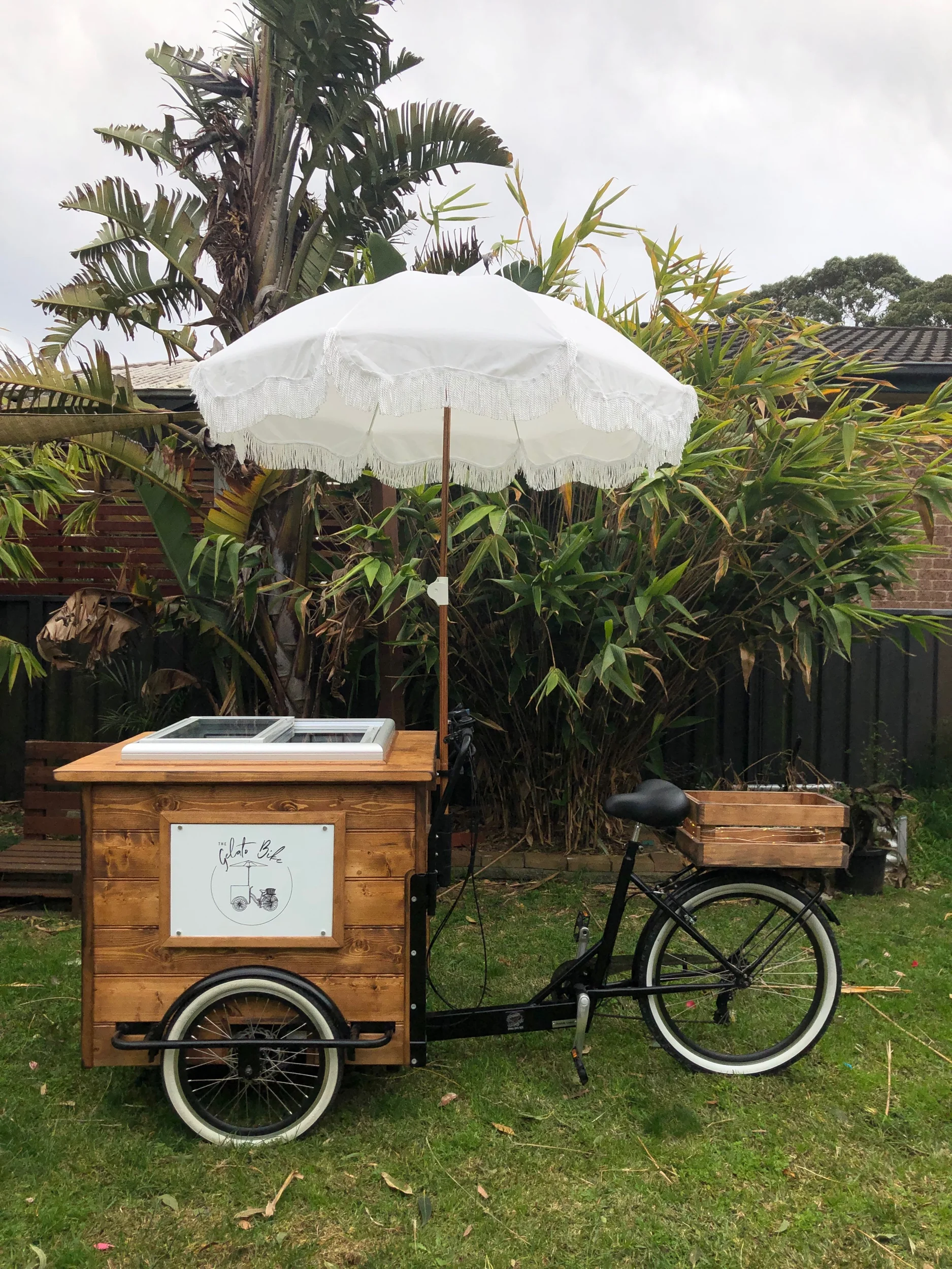 Timber gelato bike with white umbrella set up for outdoor wedding catering
