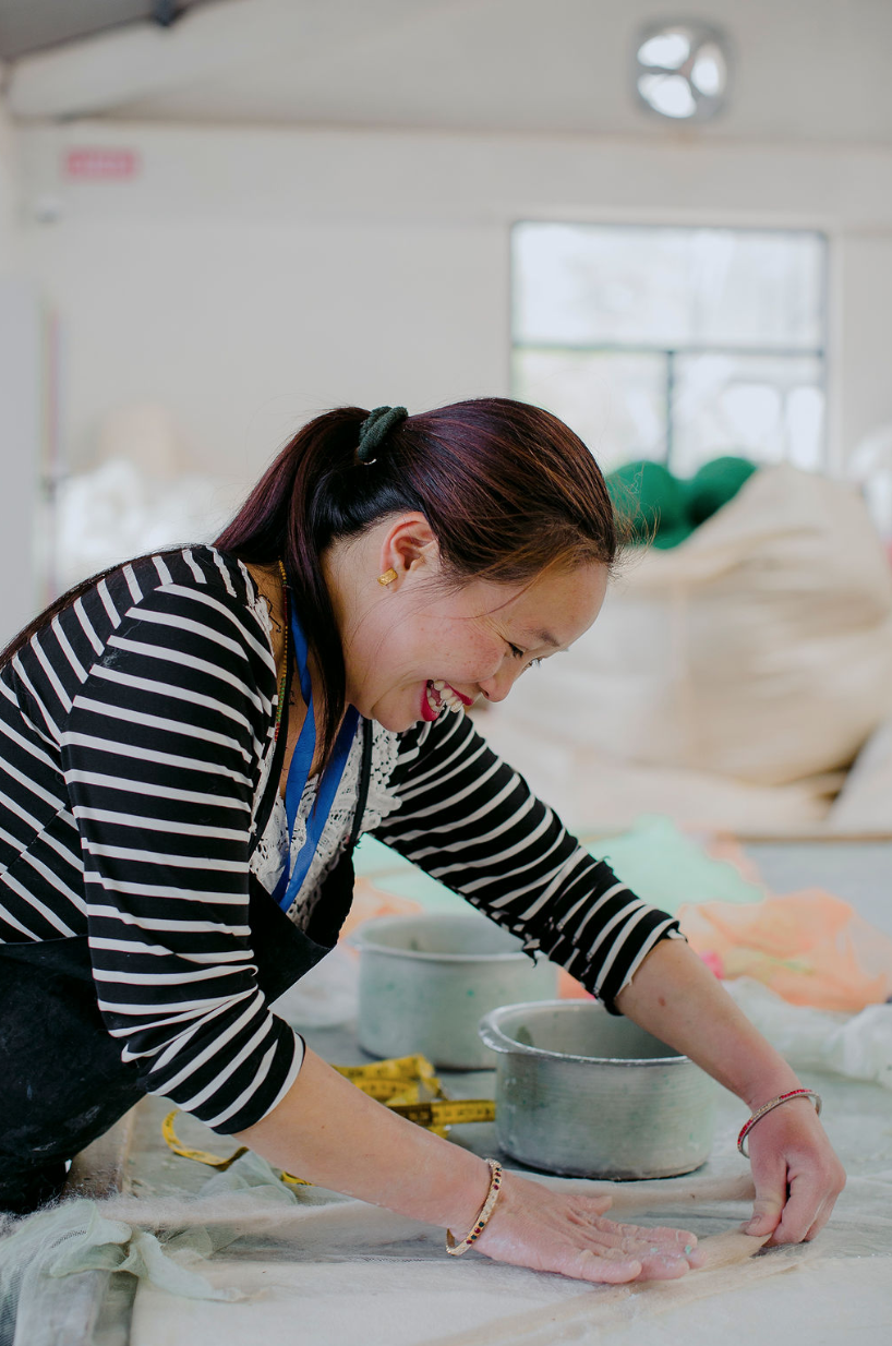 Artisan in Nepal at the cutting table making ethical fashion accessories