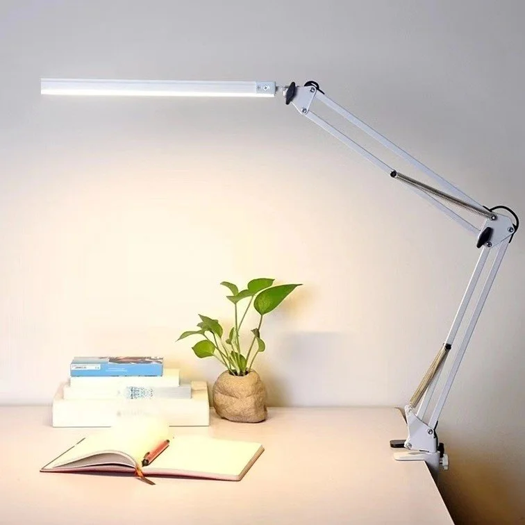 White LED swing arm desk lamp clamped to study desk with books and plant, warm light mode, Singapore home office