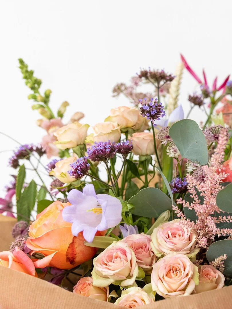 Creative florist workspace filled with fresh flowers, foliage and botanical arrangements