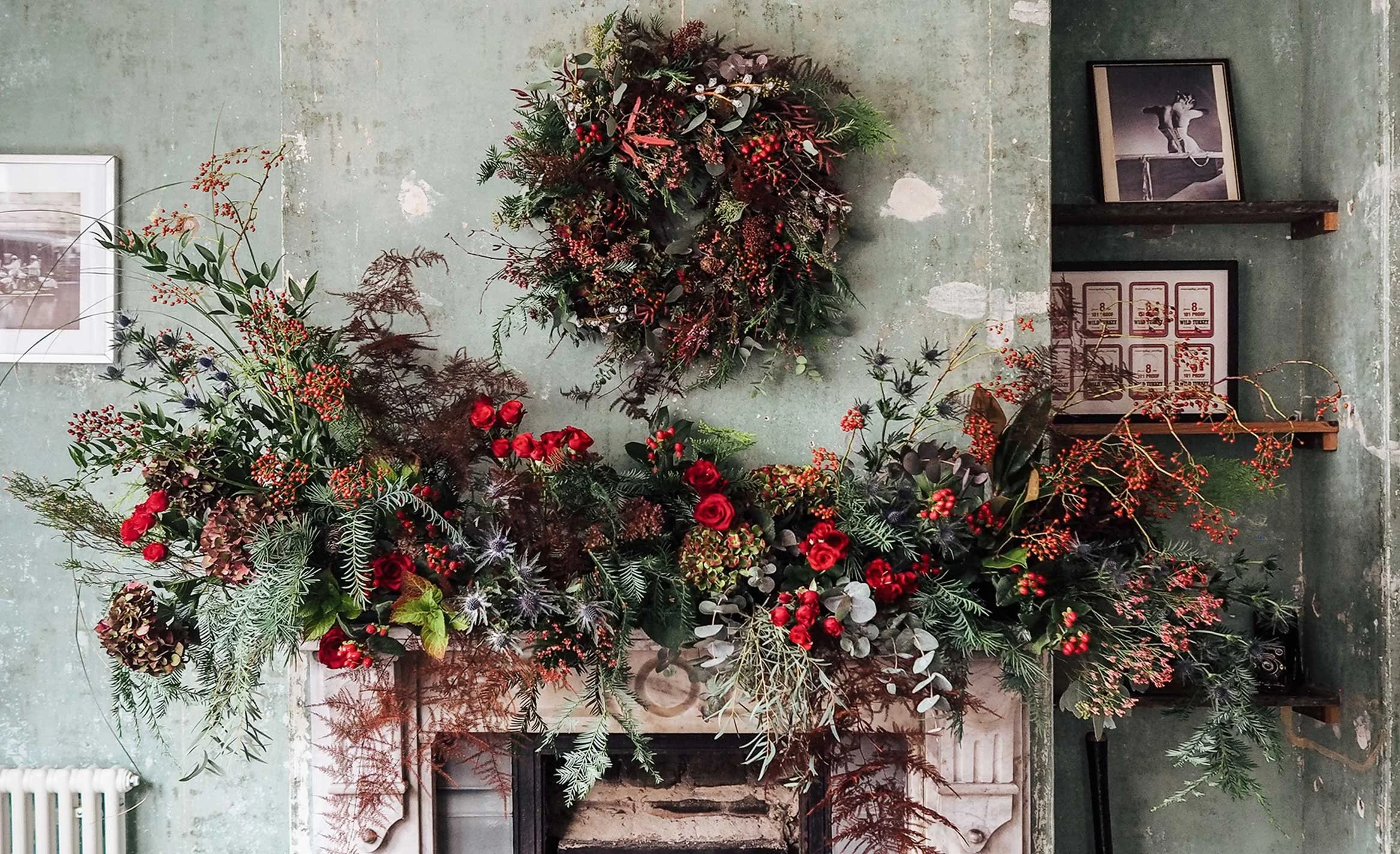 Festive mantelpiece decorated with winter greenery, candles and elegant botanical styling