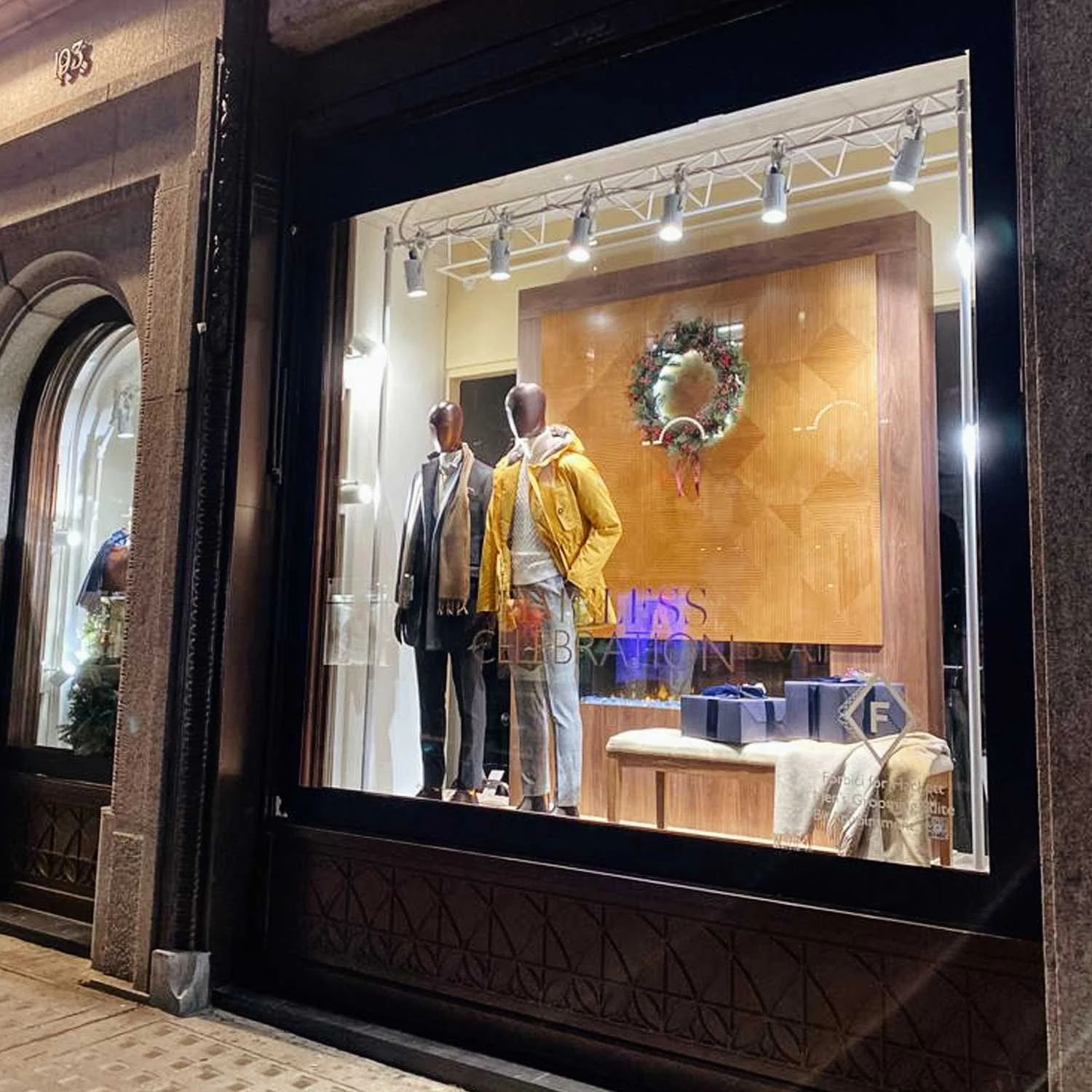Luxury Christmas window display with bespoke wreath installations and festive lighting