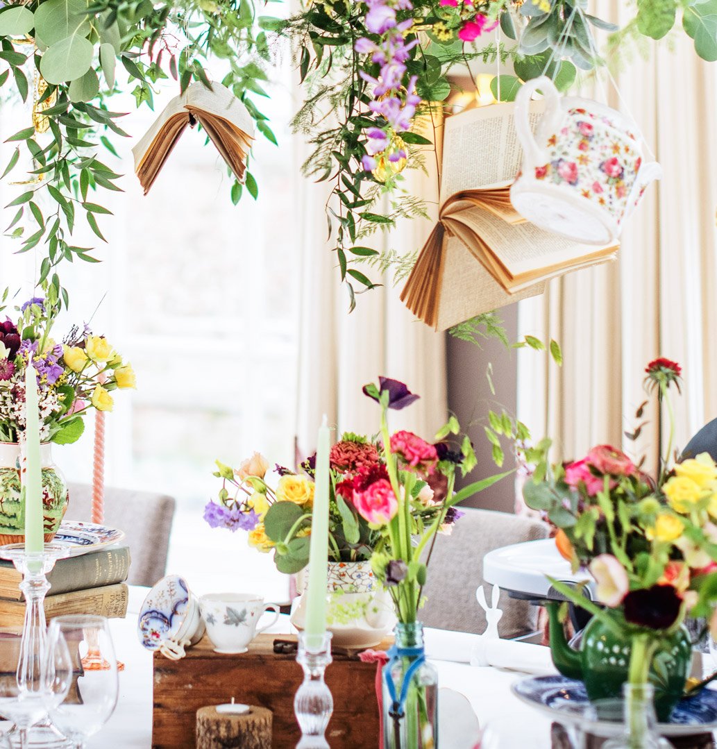 Wonderland-themed event styling with hanging teapots and floating books