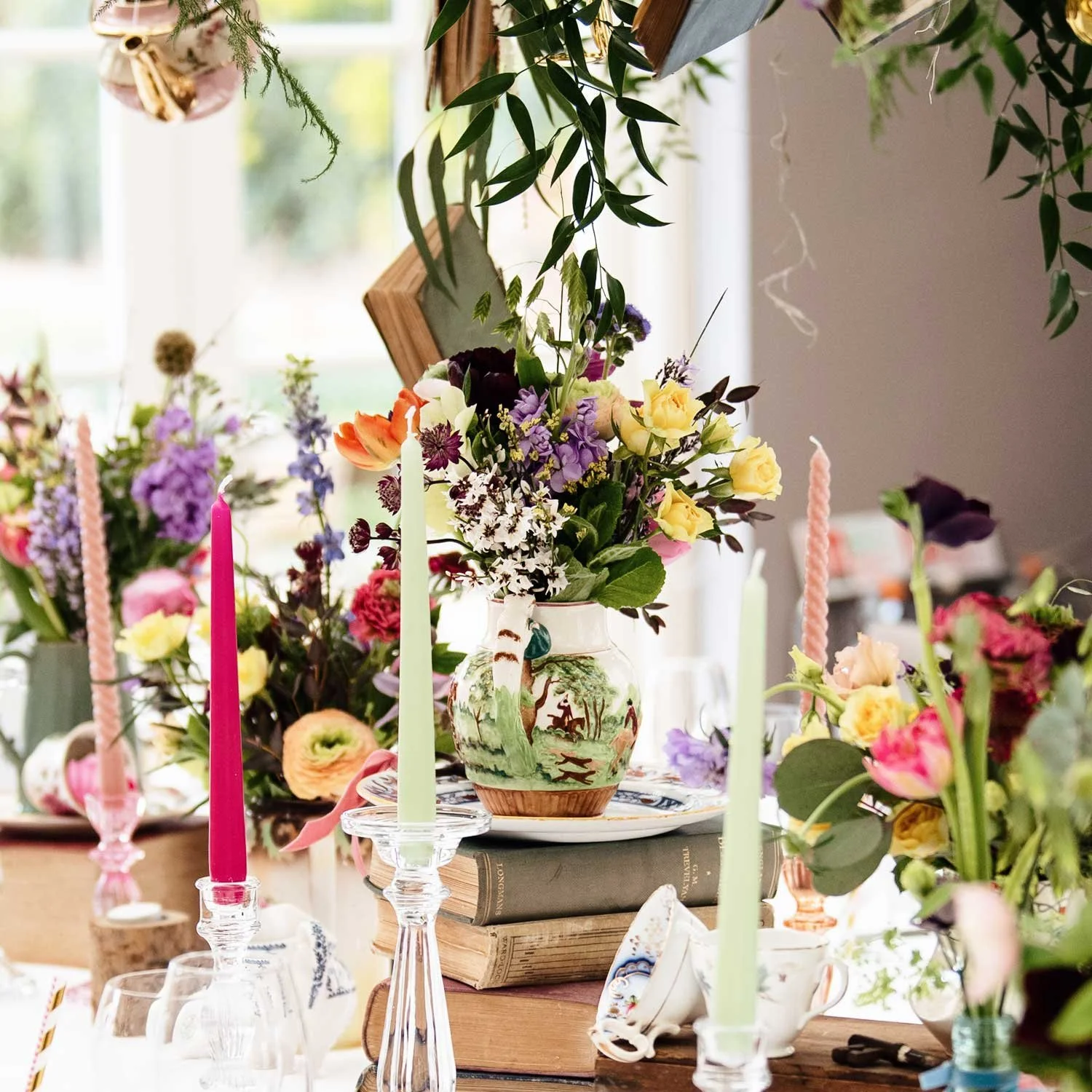 Wonderland-themed event styling with hanging teapots and floating books