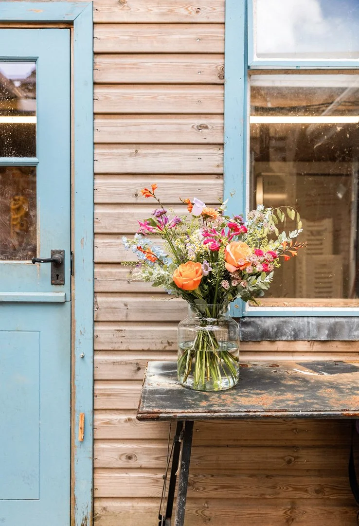 A vase of fresh flowers outside a florist’s workshop.