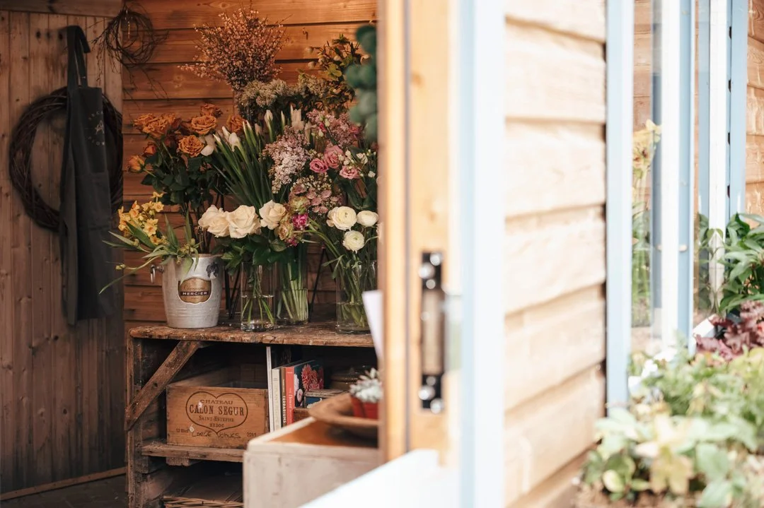 A selection of fresh flowers is seen through the doorway of a florist’s workshop.