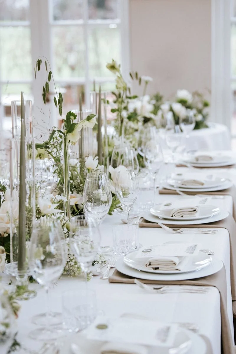 A wedding table is decorated with fresh wedding flowers and candles.