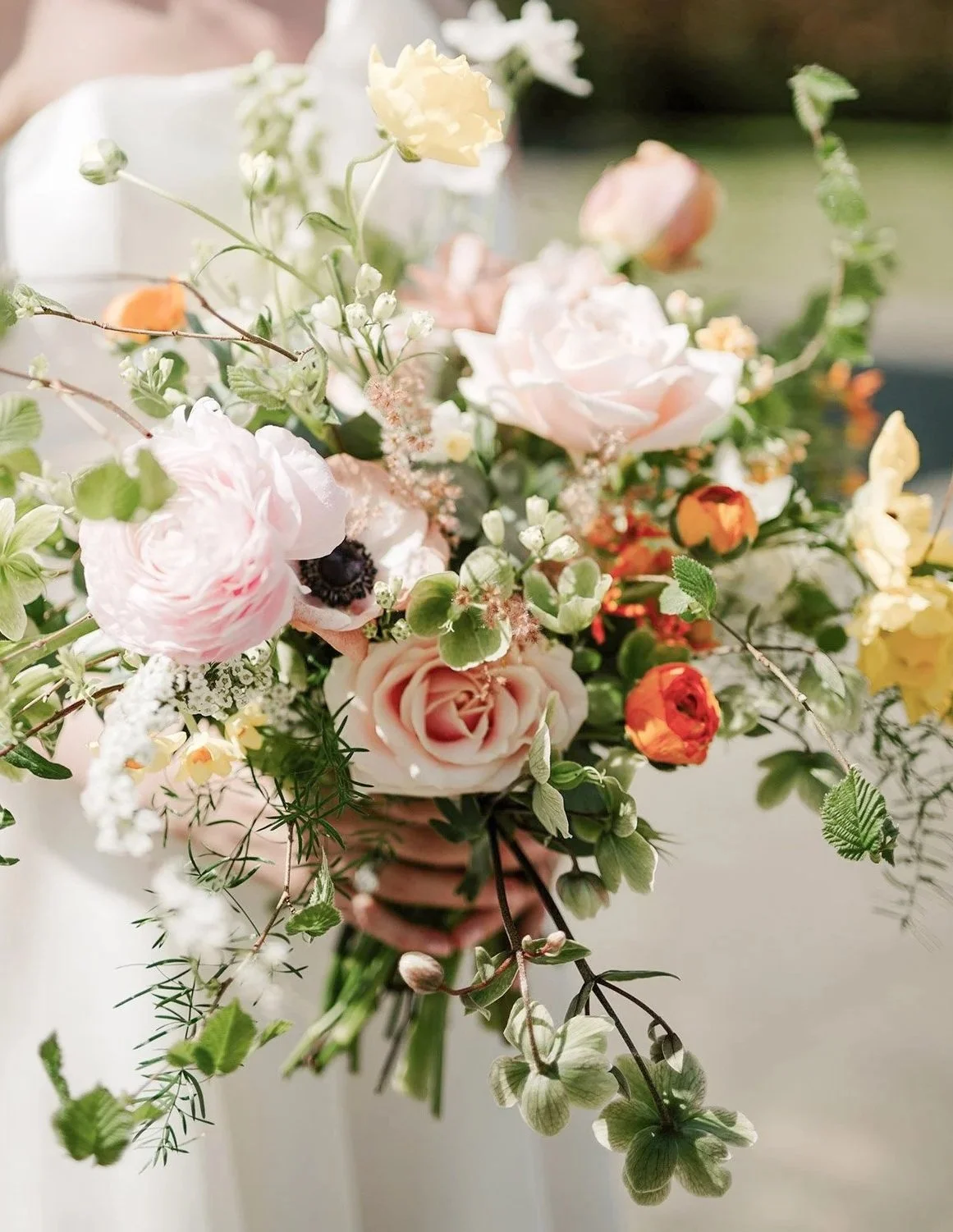 A Bride holds a stunning bouquet of fresh wedding flowers.