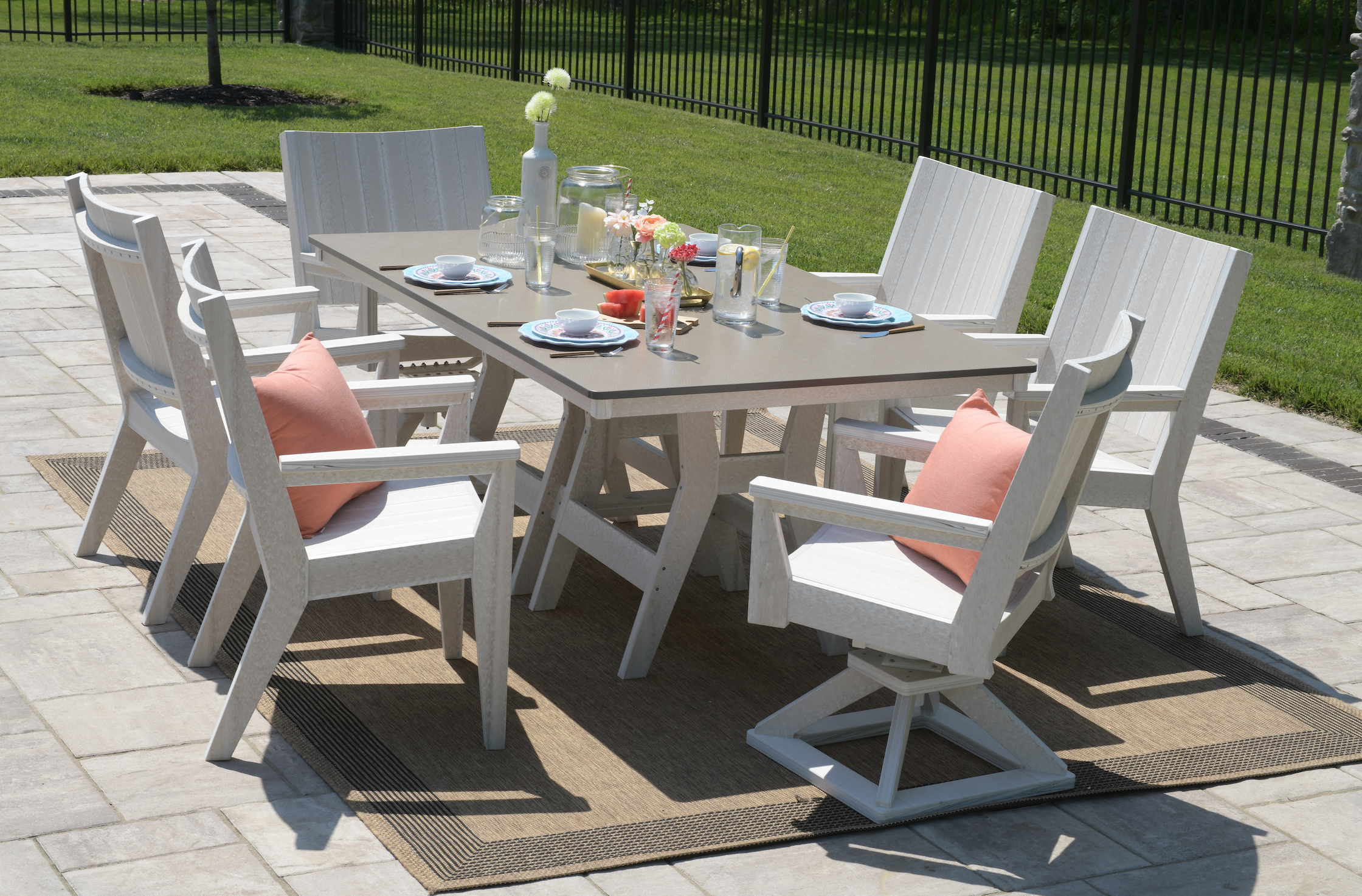  Harbor 44” x 72” rectangular dining table in seashell with bronze hammered top. Mayhew chat dining and chat swivel rocker dining chairs in seashell. Pillow in cast coral. 