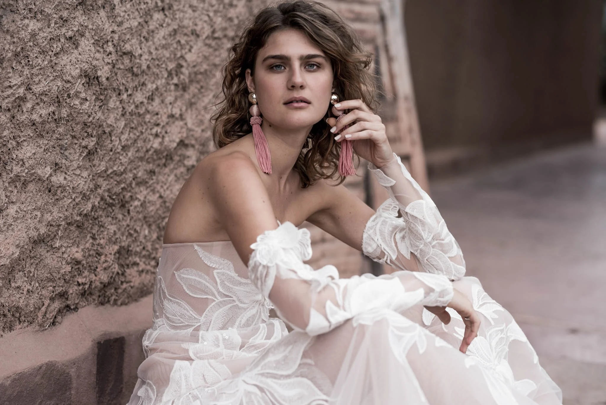 Bride wearing a blush wedding gown with long sleeves  with Iovry lace with large flower pattern and long train "Paige" by Atelier Edwin Oudshoorn