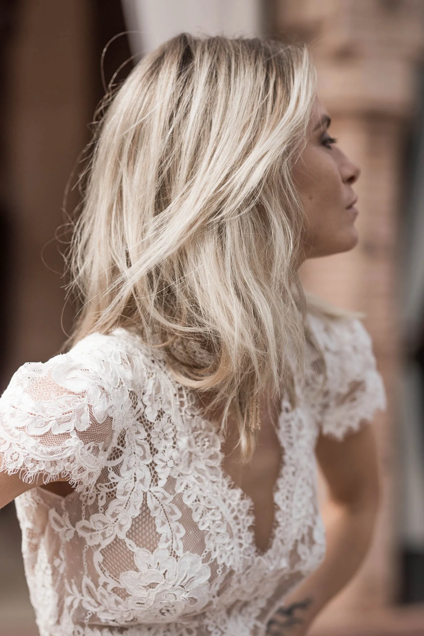Bride wears a crepe and lace wedding dress with short sleeves and open back "Lucy" by Atelier Edwin Oudshoorn