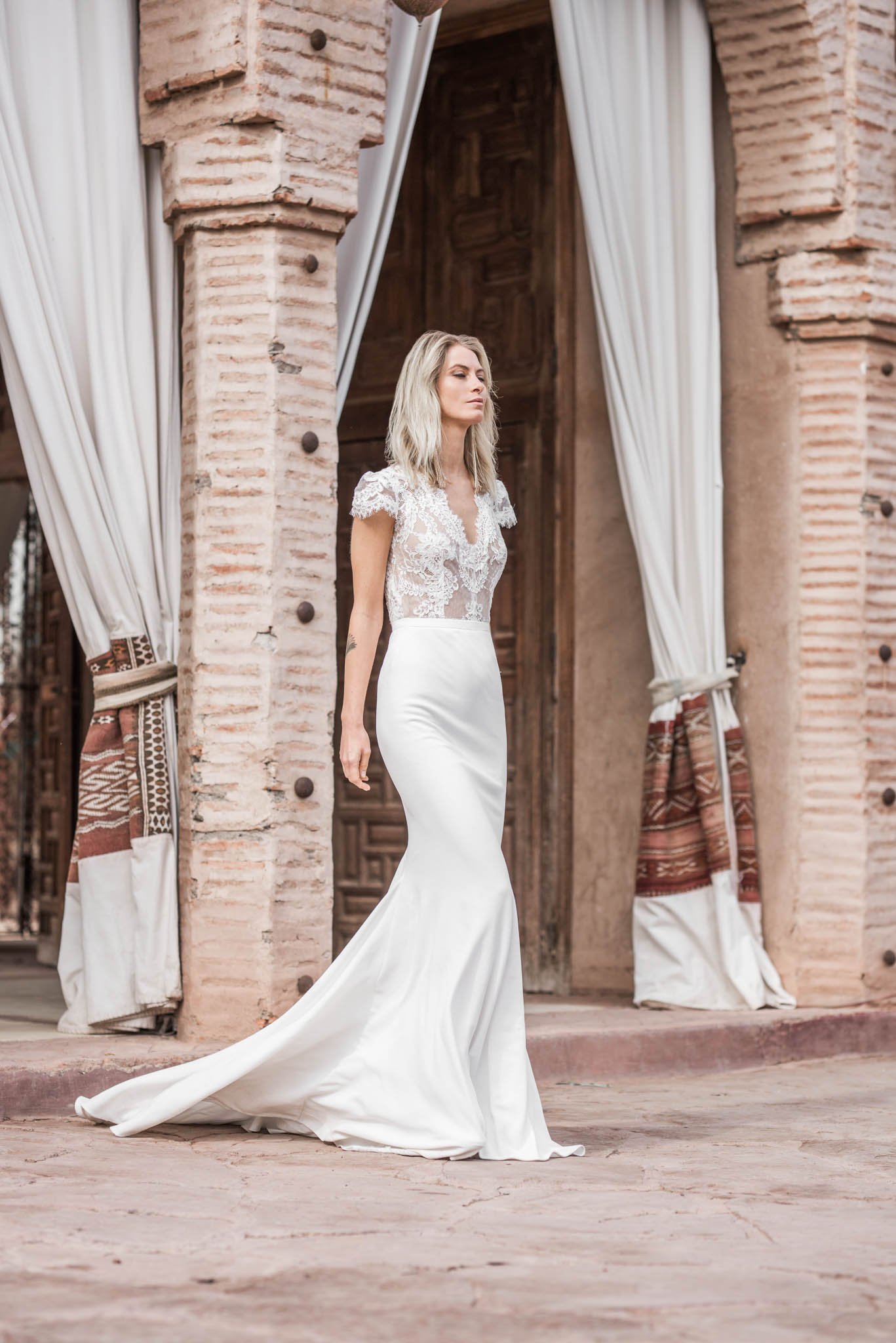 Bride wears a crepe and lace wedding dress with short sleeves and open back "Lucy" by Atelier Edwin Oudshoorn