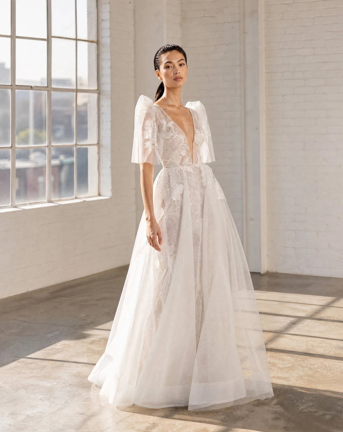 Delicate lace, layered under architectural tulle with hand applied organza floral appliques.
The statement sleeves (reminiscent of Filipiniana or Terno sleeves) also have hand applied floral appliques on Italian tulle.
