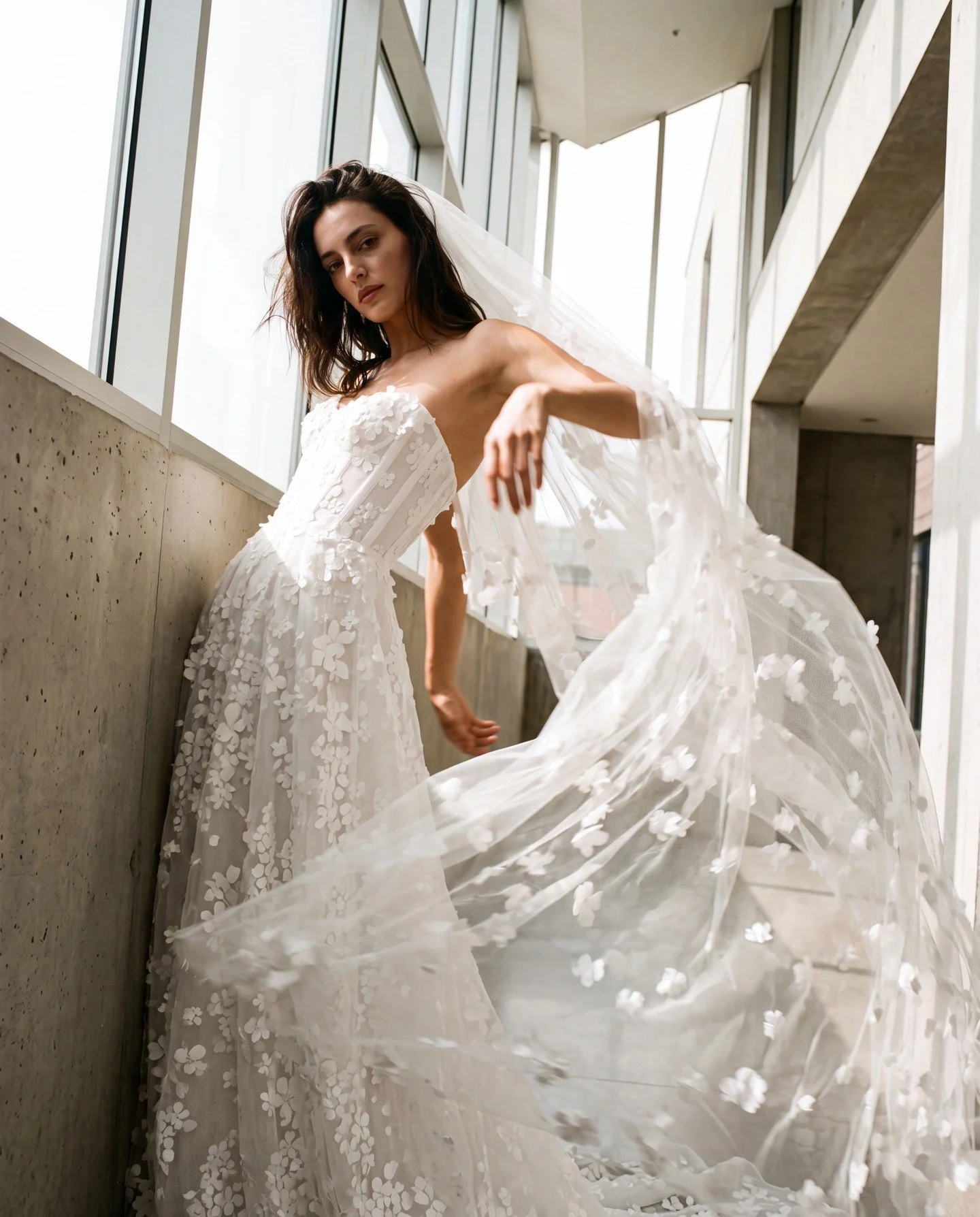 'Magnolia'.... 

Delicate floral embroidery cascades over this lightweight ballgown with custom corset.

The matching veil has scattered flowers gently falling through the Italian tulle.