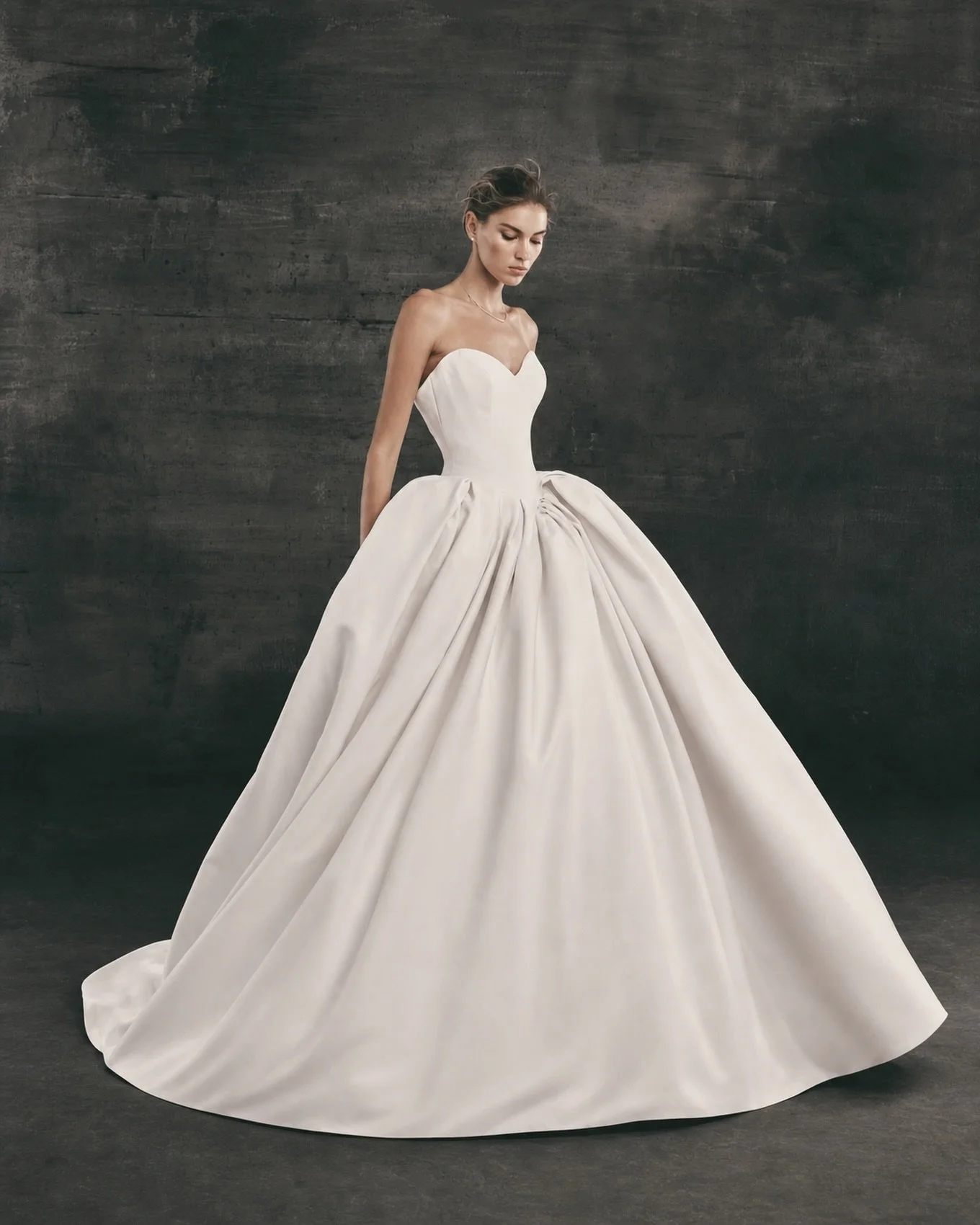 For those brides that want to go big but keep the look clean and modern. Our custom version of the NF154 from Nicole + Felicia features a full volume ballgown skirt and stunning dropped waist corset in a soft, matte mikado fabric which drapes beautif