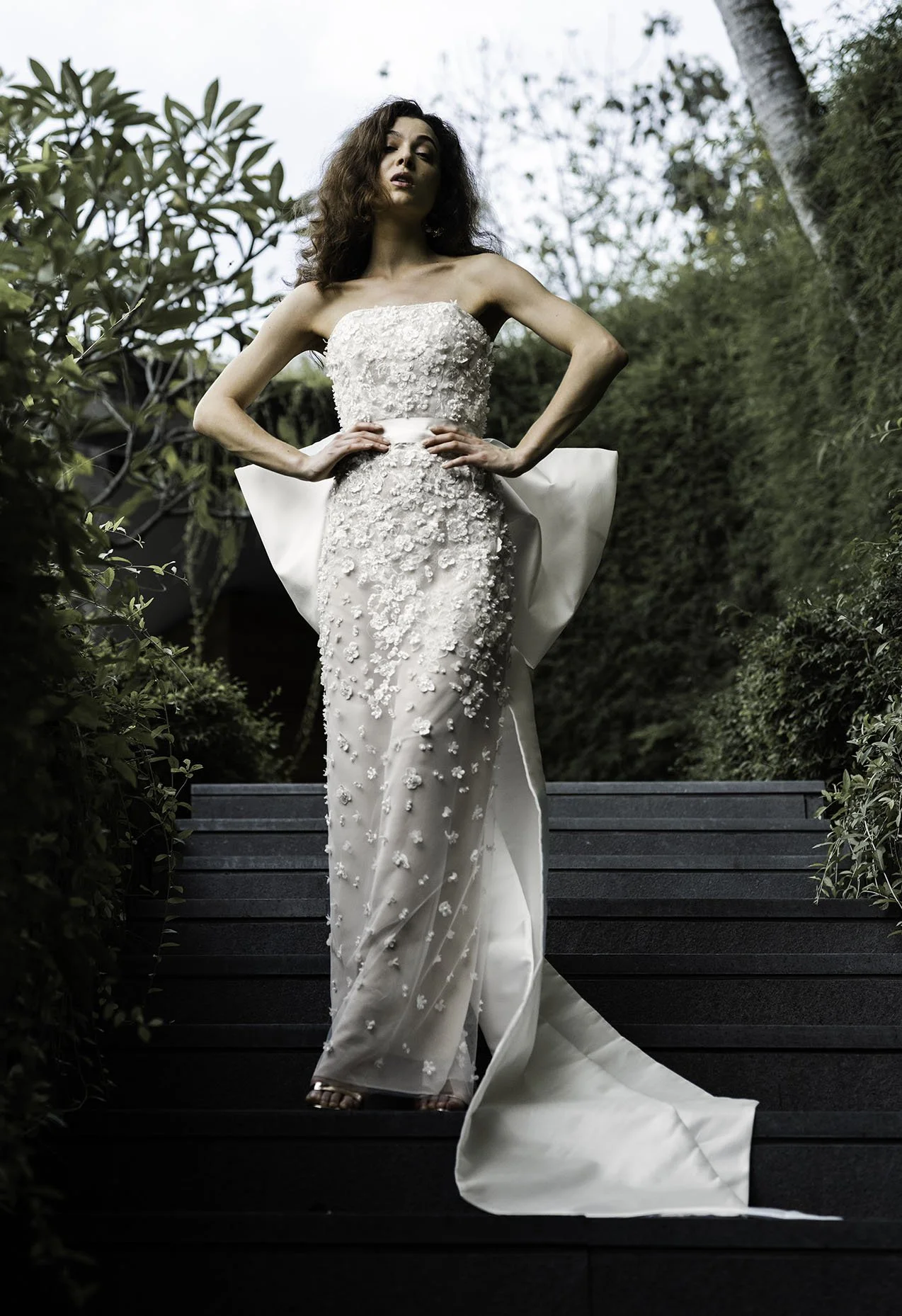 Woman wearing column wedding gown in beaded lace with oversized bow at back "Marlow" by Atelier Edwin Oudshoorn