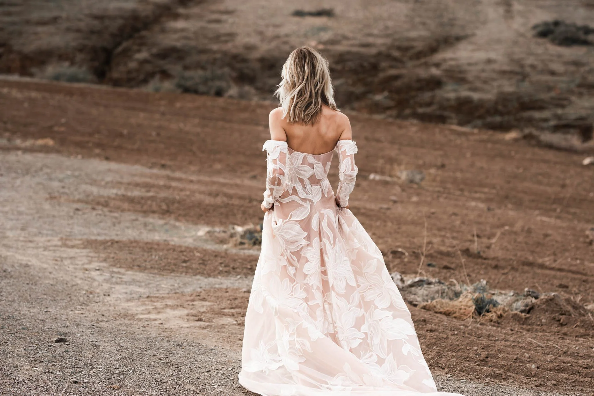 Bride wearing a blush wedding gown with Iovry lace with large flower pattern and long train "Paige" by Atelier Edwin Oudshoorn