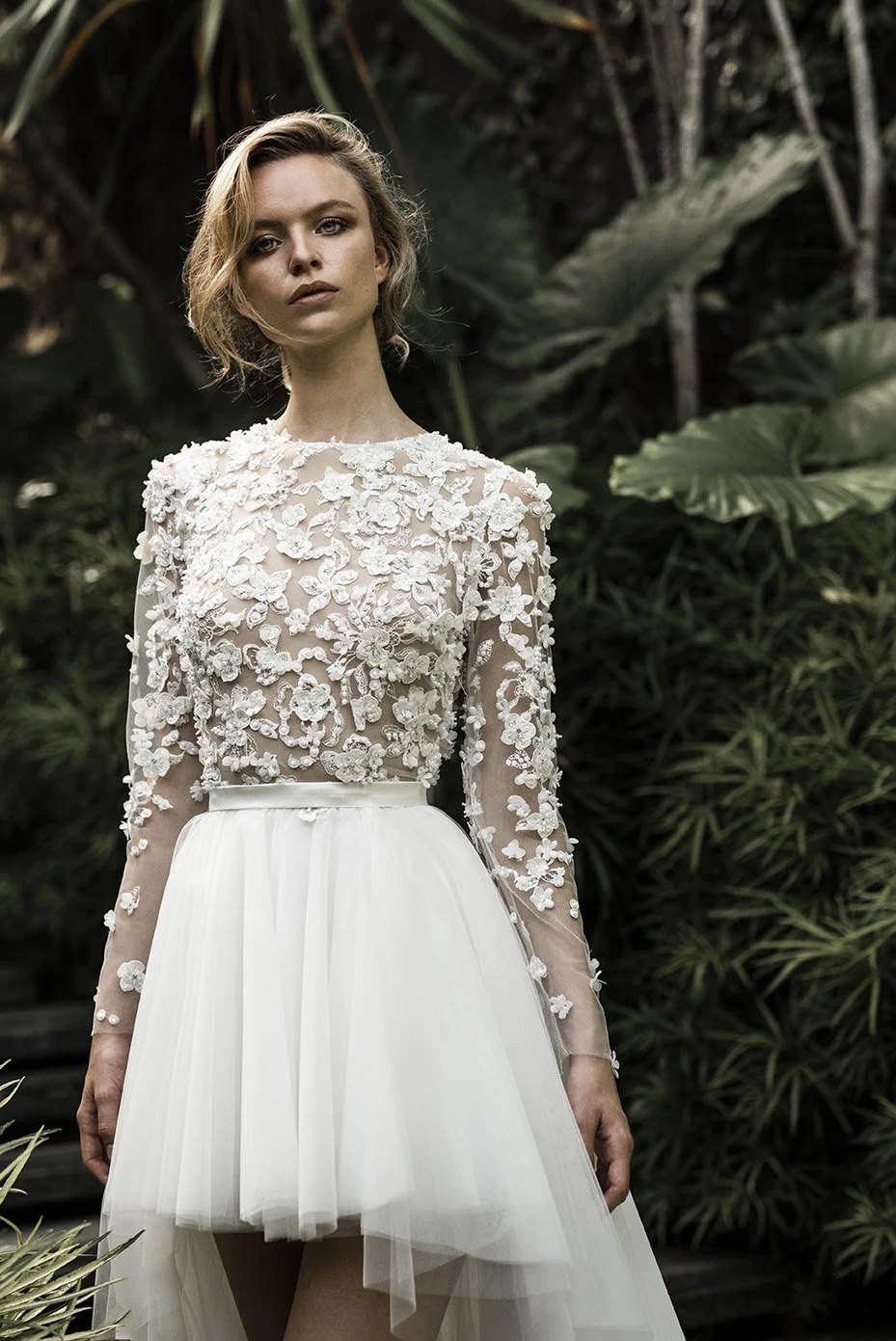 Woman in HighLow wedding gown with tulle skirt and embroidered top with long sleeves "Noor" by Atelier Edwin Oudshoorn
