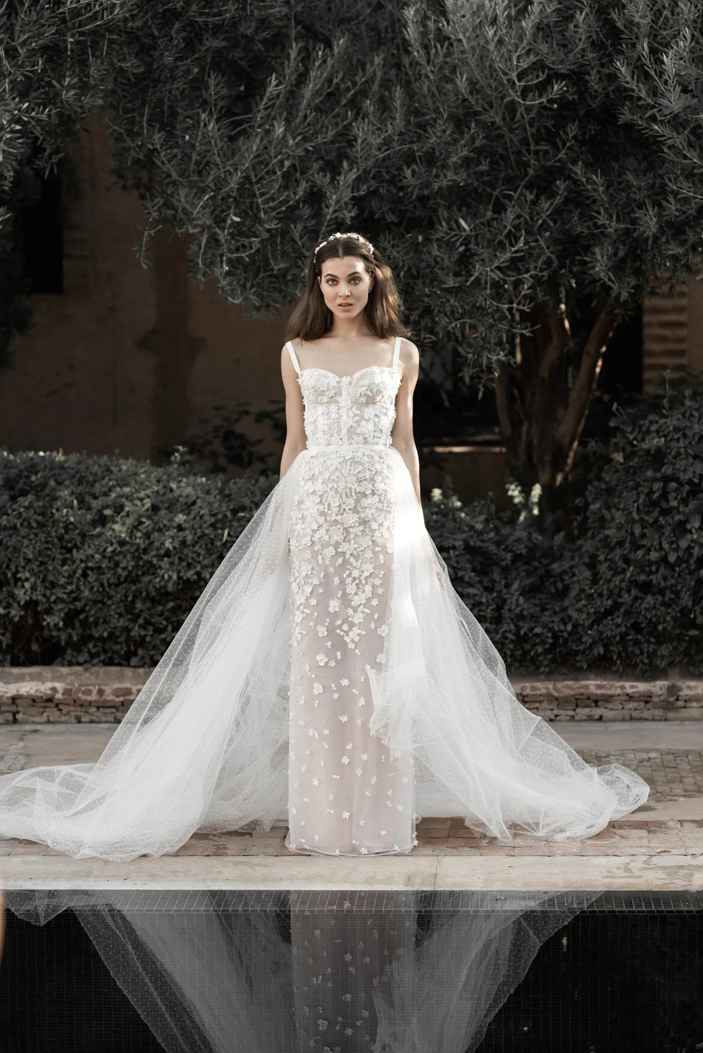 Brides wears intricately beaded silk and tulle column wedding dress with tulle overskirt from designer Edwin Oudshoron