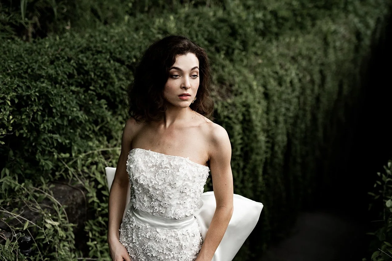 Woman wearing column wedding gown in beaded lace with oversized bow at back "Marlow" by Atelier Edwin Oudshoorn