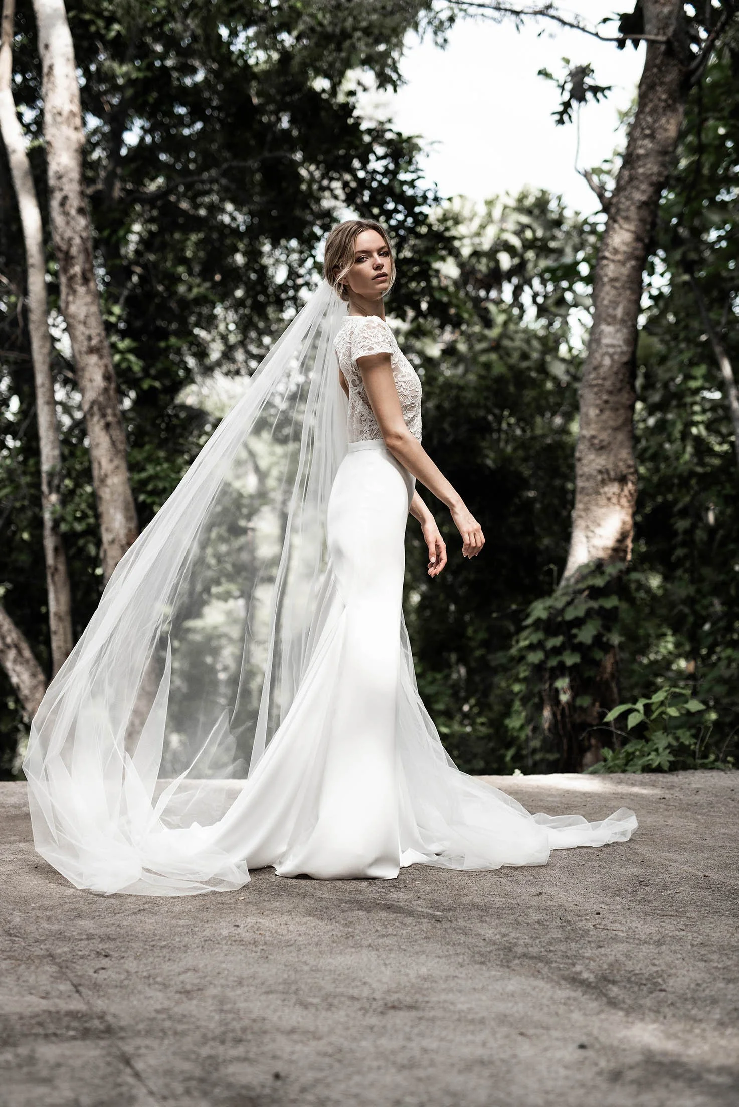 Woman wears white crepe wedding dress with lace top with short sleeves "Quinn" by Atelier Atelier Edwin Oudshoorn