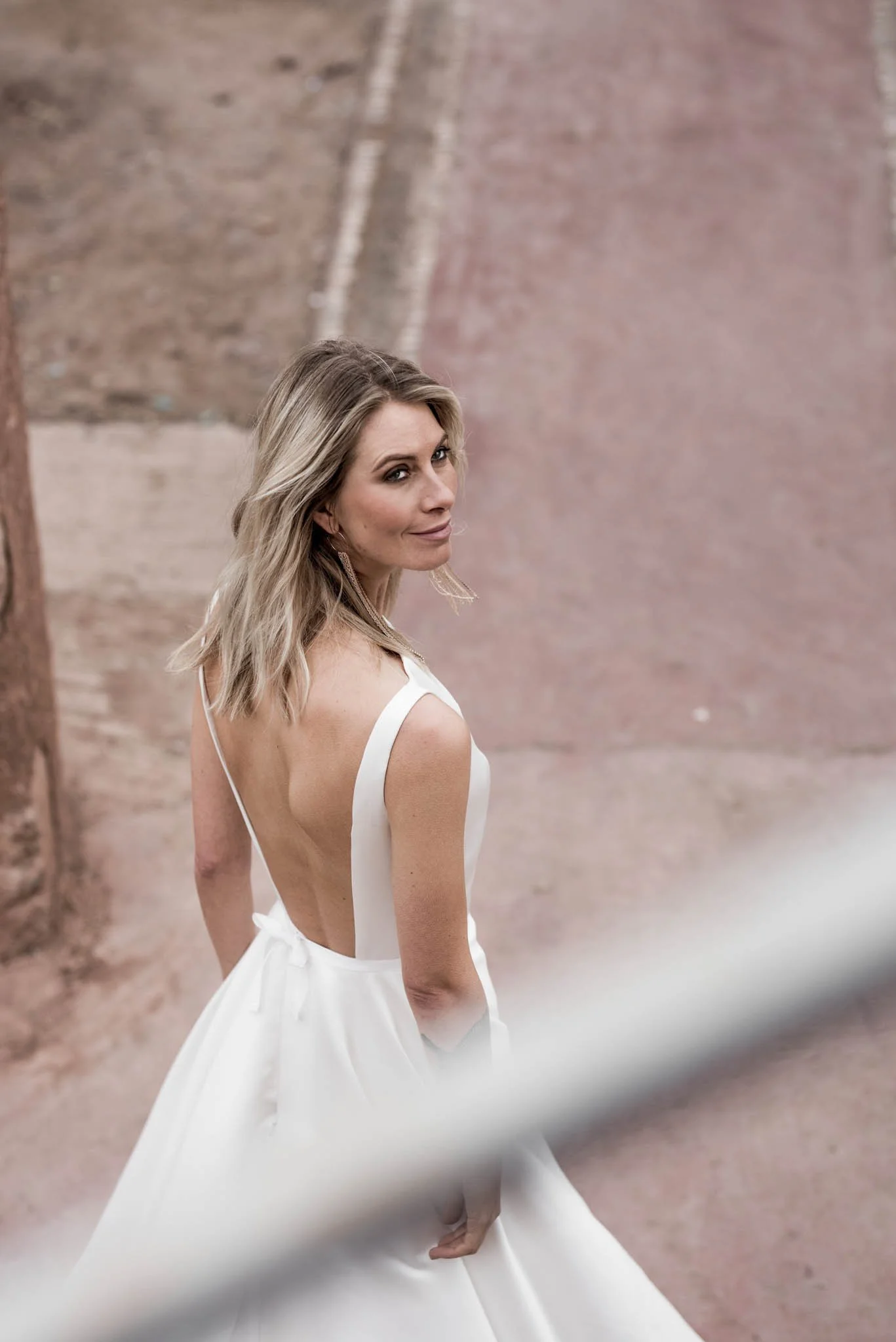 Model wears Satin wedding gown with modest neckline and long train
