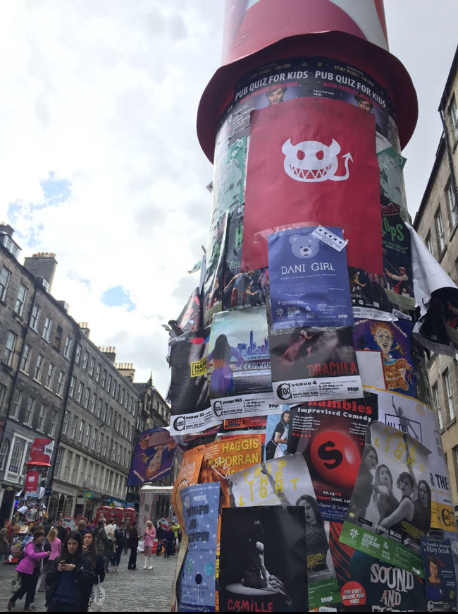 One of the large pillars on The Royal Mile with a Dani Girl poster soon to be covered up by hundreds of other posters.