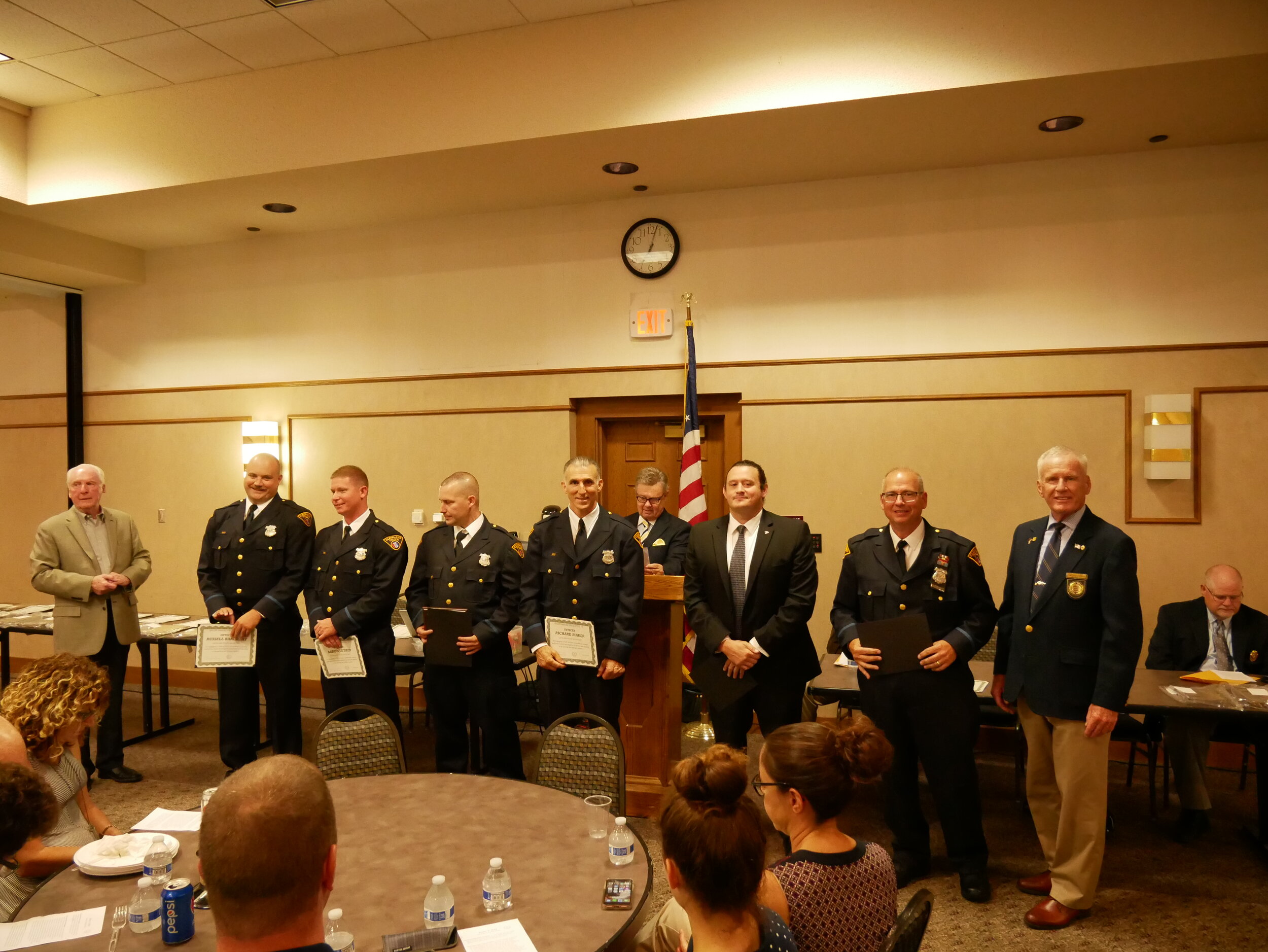  Board Member Pat Reynolds with President Tim Leahy on the right and Board Member Mike Dugan in the background present the Bravery Award to 5th District Officers Russel Barnhart, Aaron Luther, Michael Janusczak, Richard Mauer, Donald Nutti &amp; Kevi