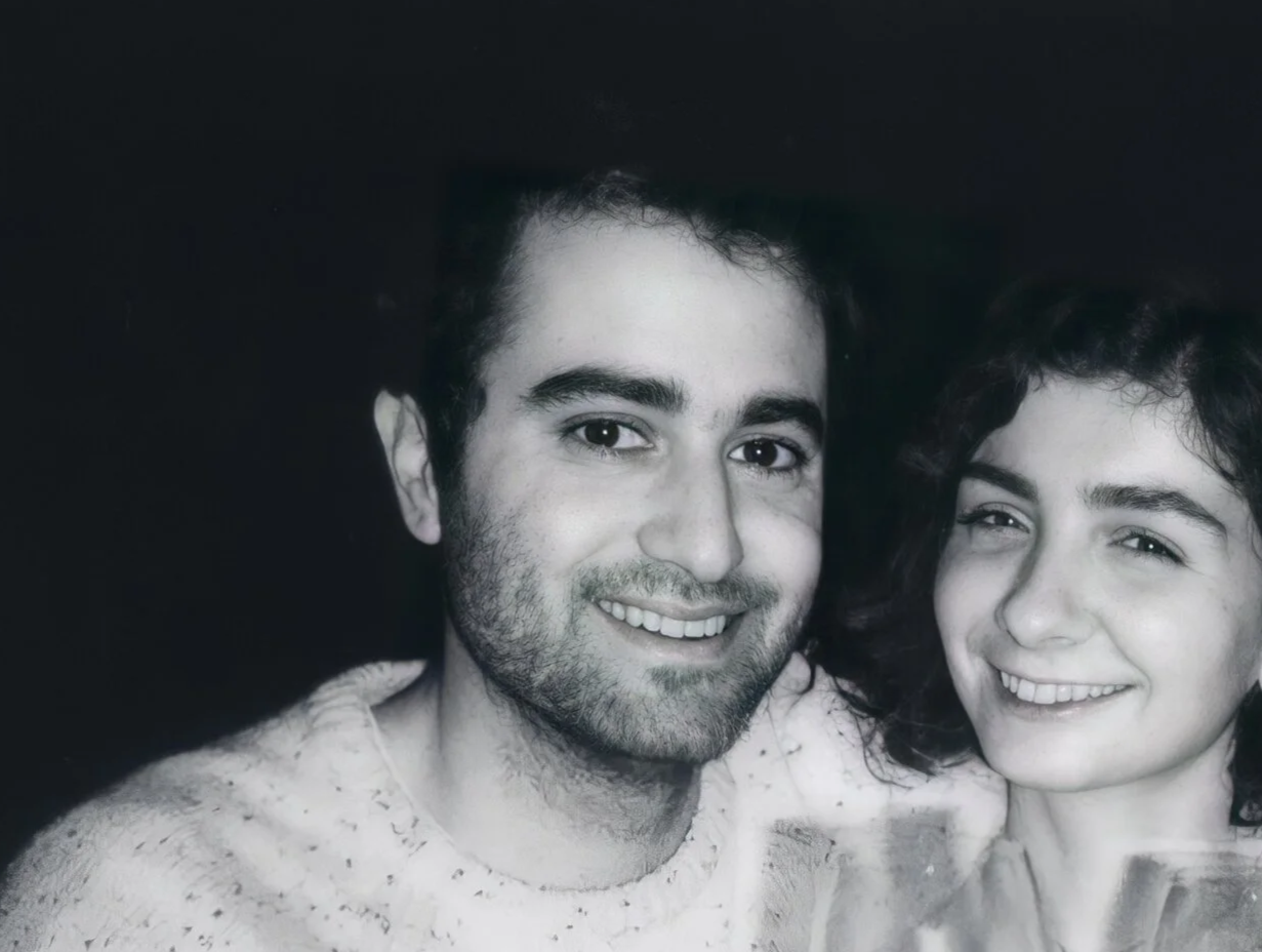 Jermey Smiling with dark hair and beard, and smiling woman with curly hair, both in black and white.