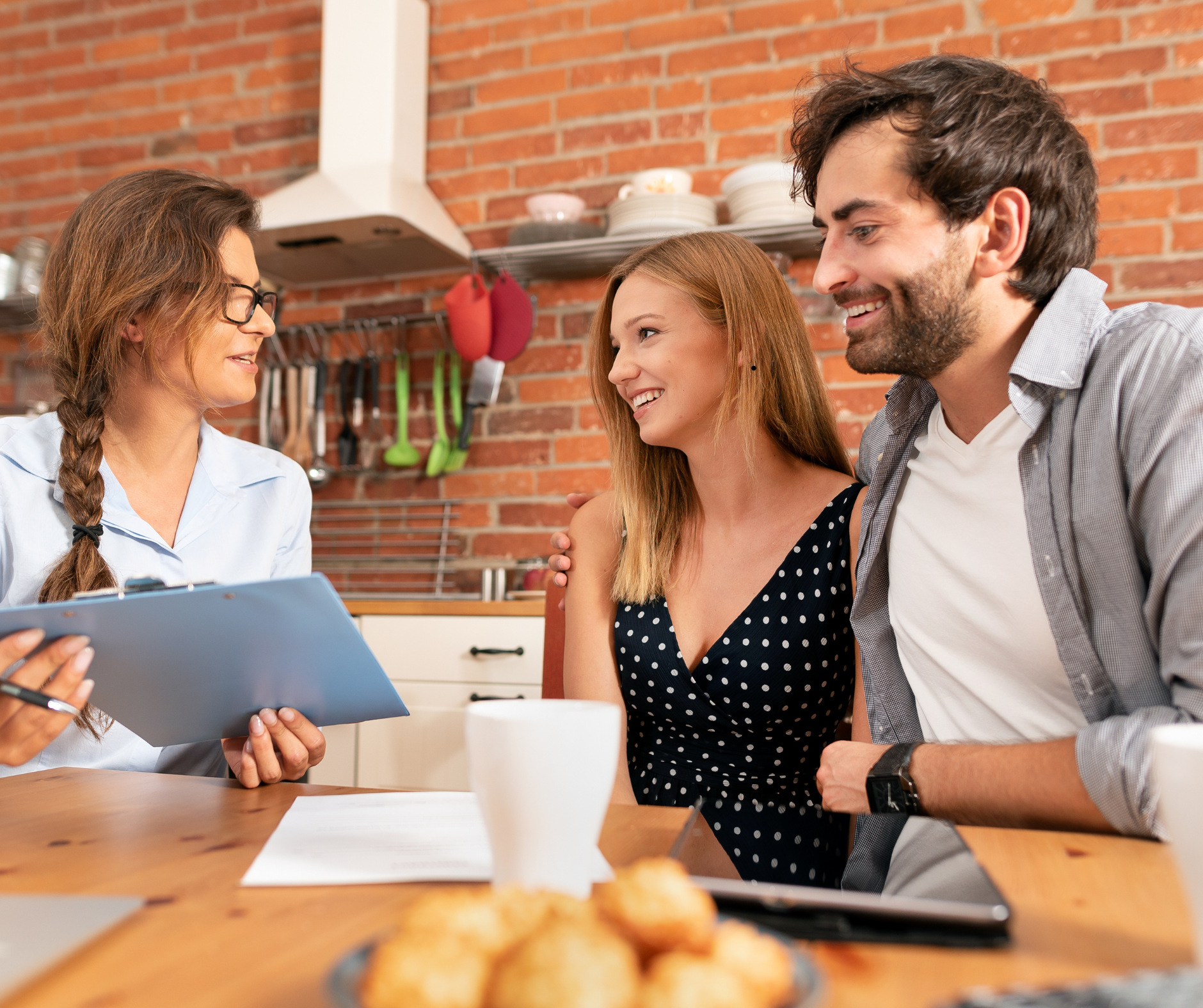 Homeowners reviewing renovation details with a contractor in their kitchen during a friendly consultation.