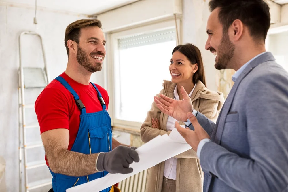 Homeowners discussing renovation plans and project details with a contractor during the early planning stage of a home renovation.