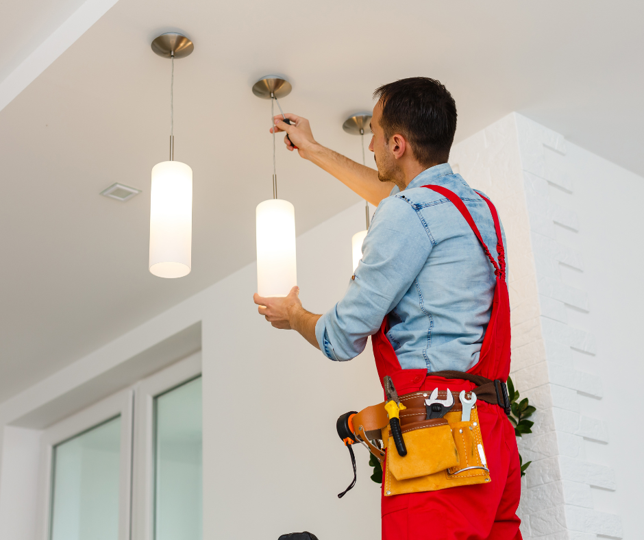 Licensed electrical contractor installing pendant lights in a residential home renovation project, demonstrating professional electrical workmanship and safety compliance.
