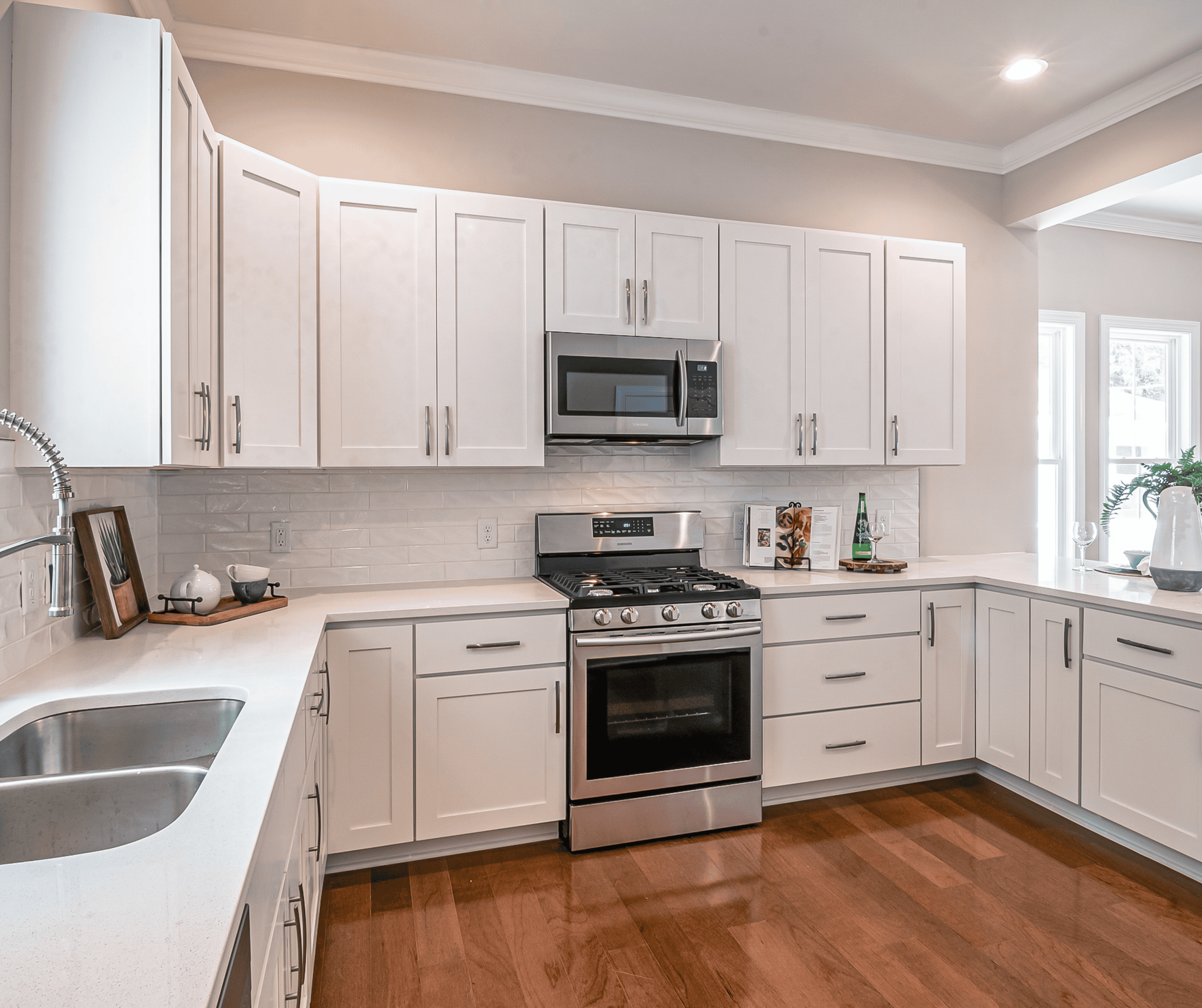 Refaced kitchen with new white shaker cabinet doors installed on existing cabinet boxes while maintaining the original kitchen layout.