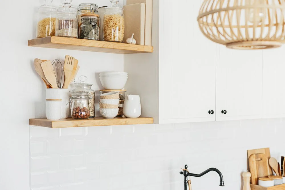 Open wood shelving with decorative kitchen storage and glass jars in a bright modern kitchen design.