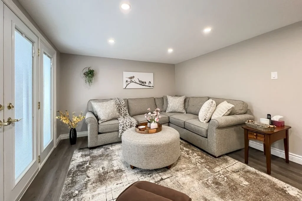 Finished basement seating area with vinyl plank flooring and pot lights in North Oshawa renovation