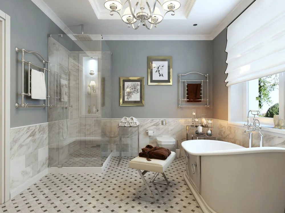 Elegant bathroom with a glass walk-in shower, rainfall showerhead, freestanding tub and patterned tile floor.