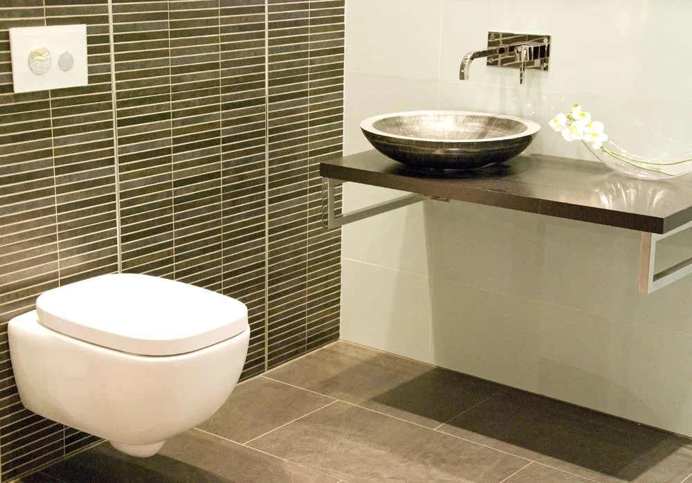 Modern powder room with floating vanity, vessel sink, wall-mounted toilet, and space-saving contemporary design