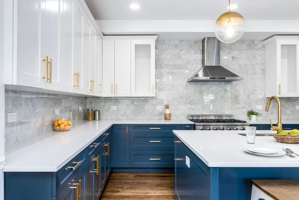 Kitchen renovation showcasing blue lower cabinets, white uppers, marble backsplash, and quartz countertops, emphasizing cabinet and countertop selection during the design phase.