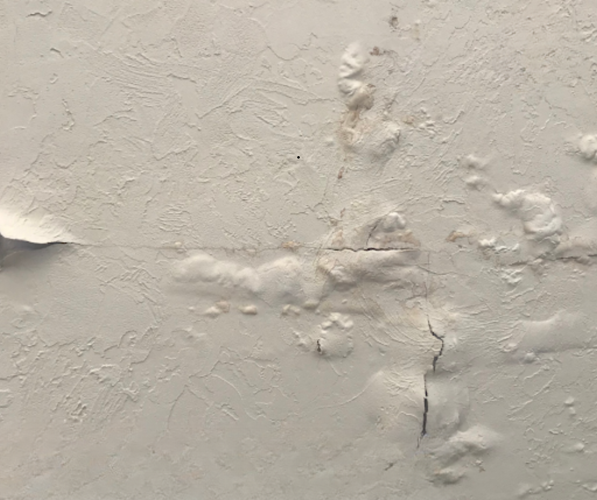Close-up of bubbling drywall caused by prolonged water exposure, showing how hidden moisture can damage walls over time.