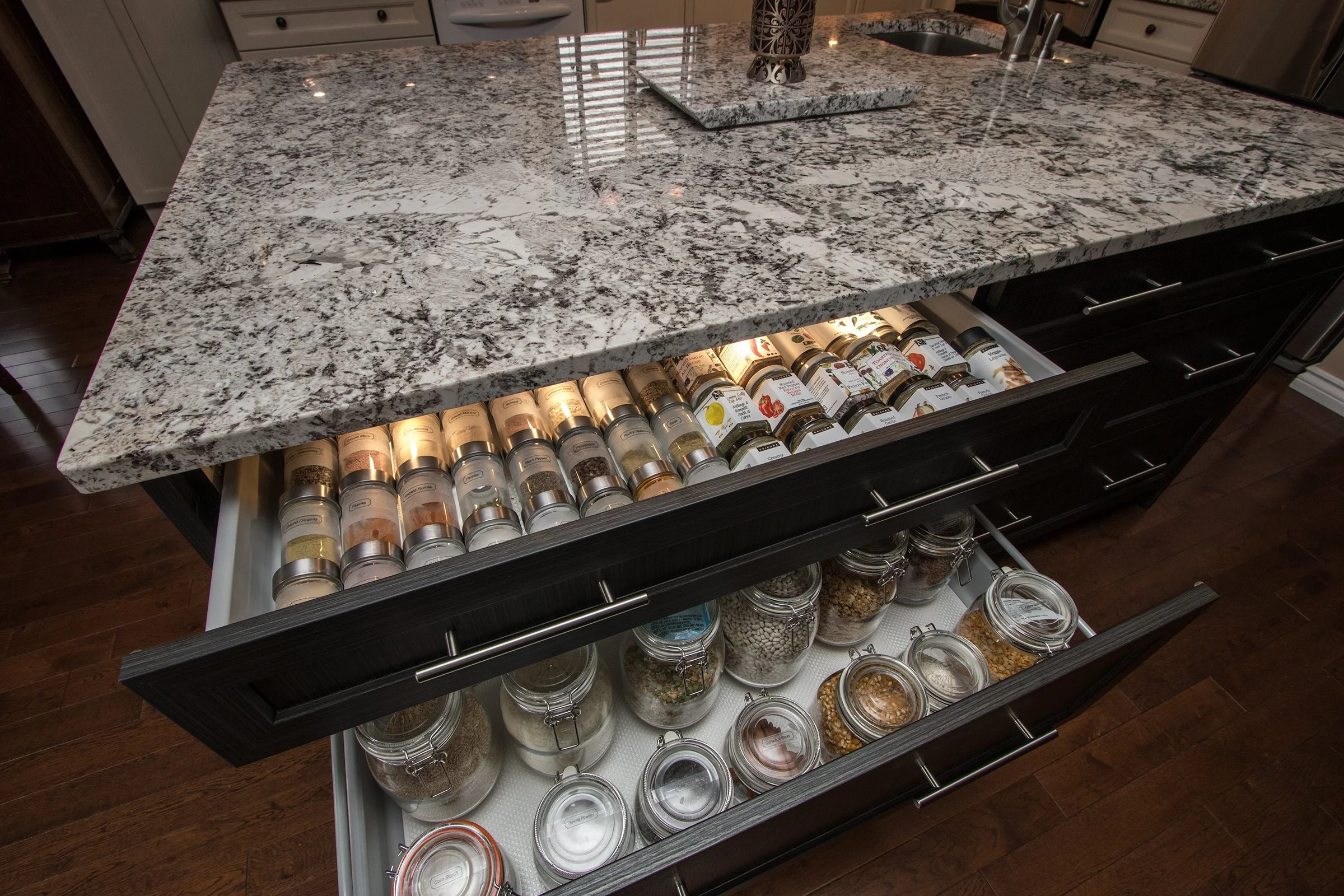 Wide kitchen spice drawer with organized jars and pantry staples stored neatly for quick visibility and access.