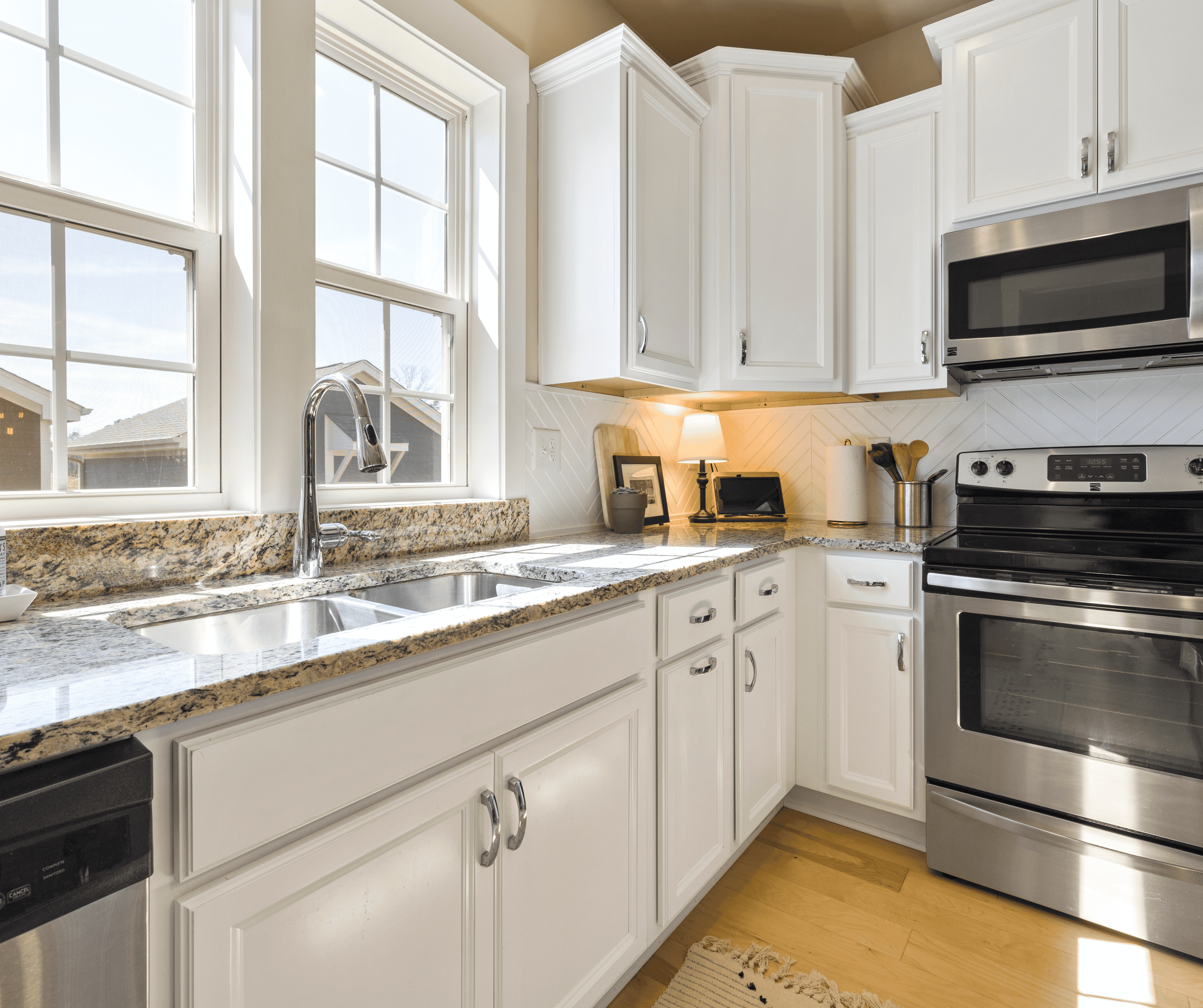 Kitchen with refaced white cabinet doors and drawer fronts installed on original cabinets in an older kitchen layout.