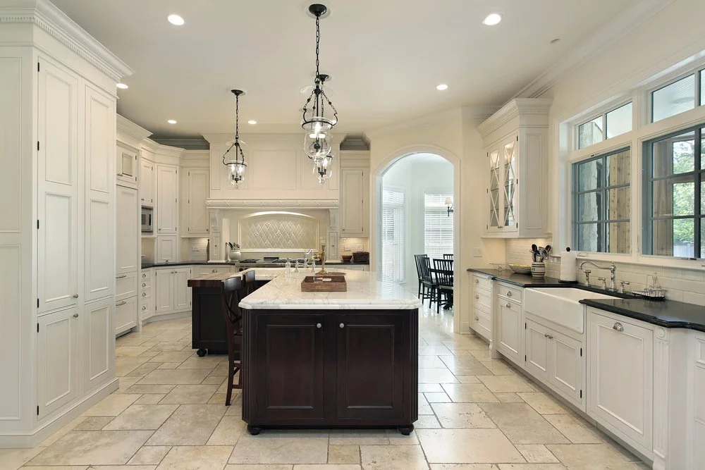 Spacious traditional kitchen renovation with a central island, custom cabinetry, and classic lighting, showing how layout and design decisions come together during a full kitchen renovation.