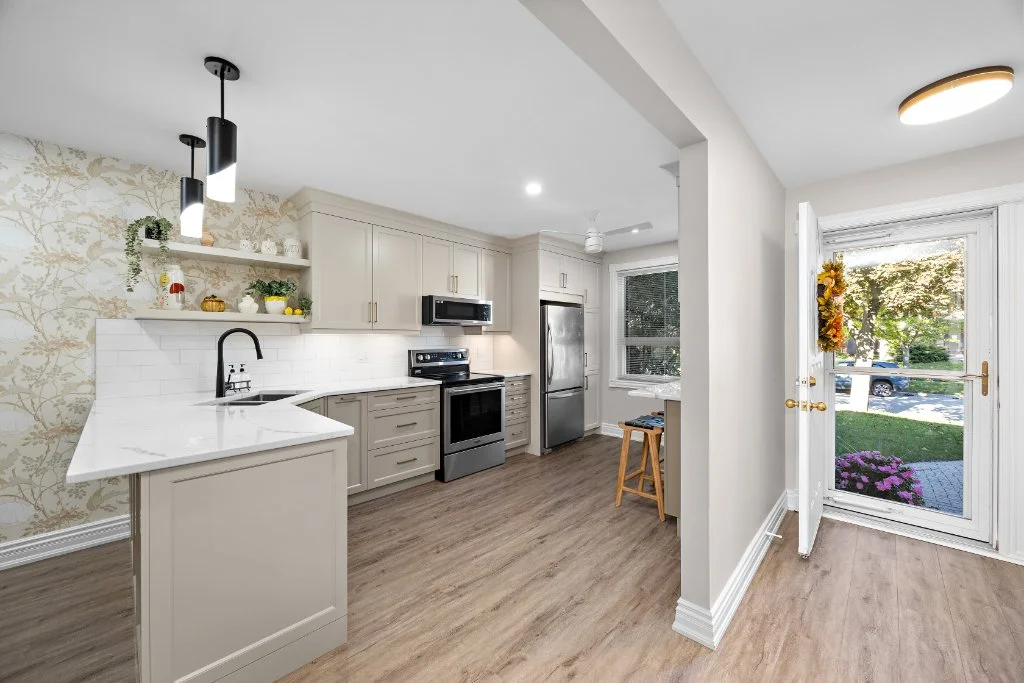 Open concept main floor renovation in North Oshawa showing new vinyl plank flooring and widened kitchen entrance