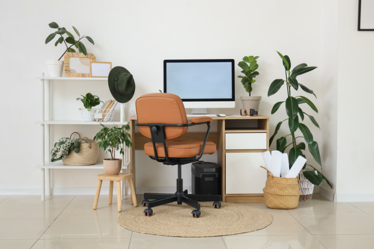 Small functional home office with a desk, computer, storage shelving and plants.