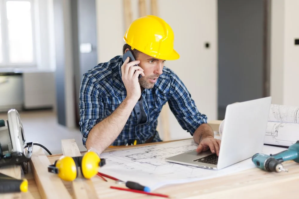 Professional contractor reviewing renovation plans and coordinating project details