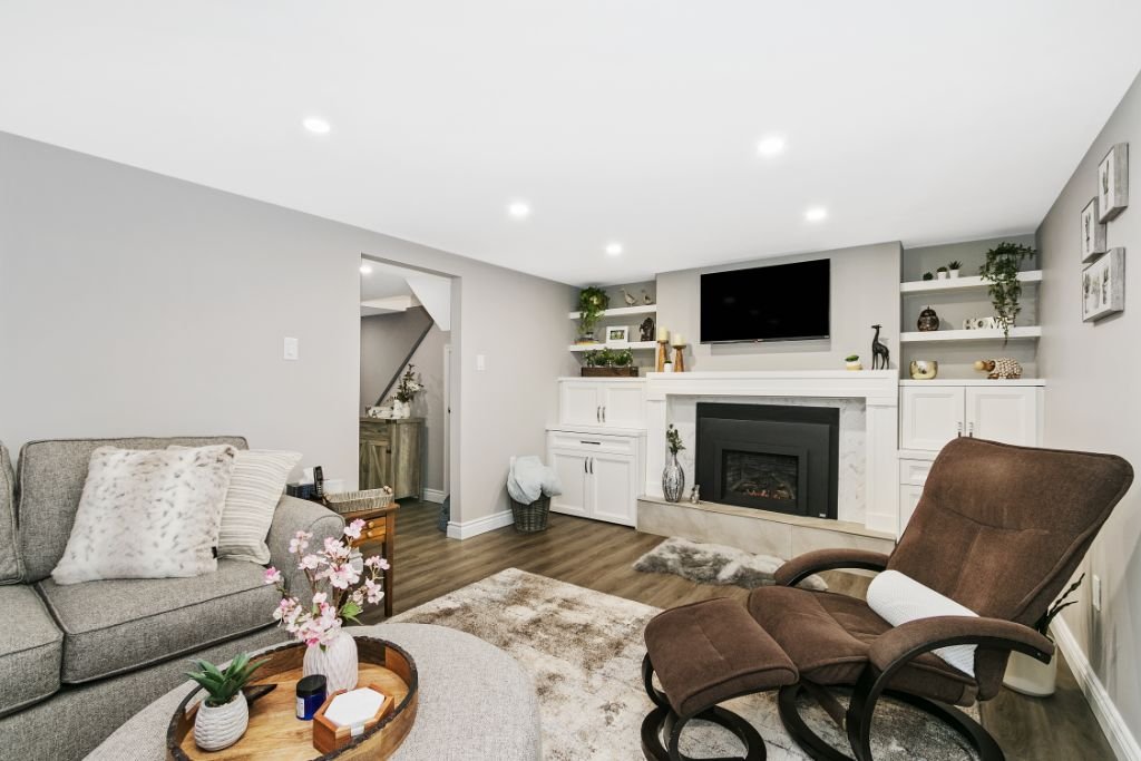 Custom built-in cabinetry and fireplace feature wall in North Oshawa basement renovation by Multi-Trade Building Services