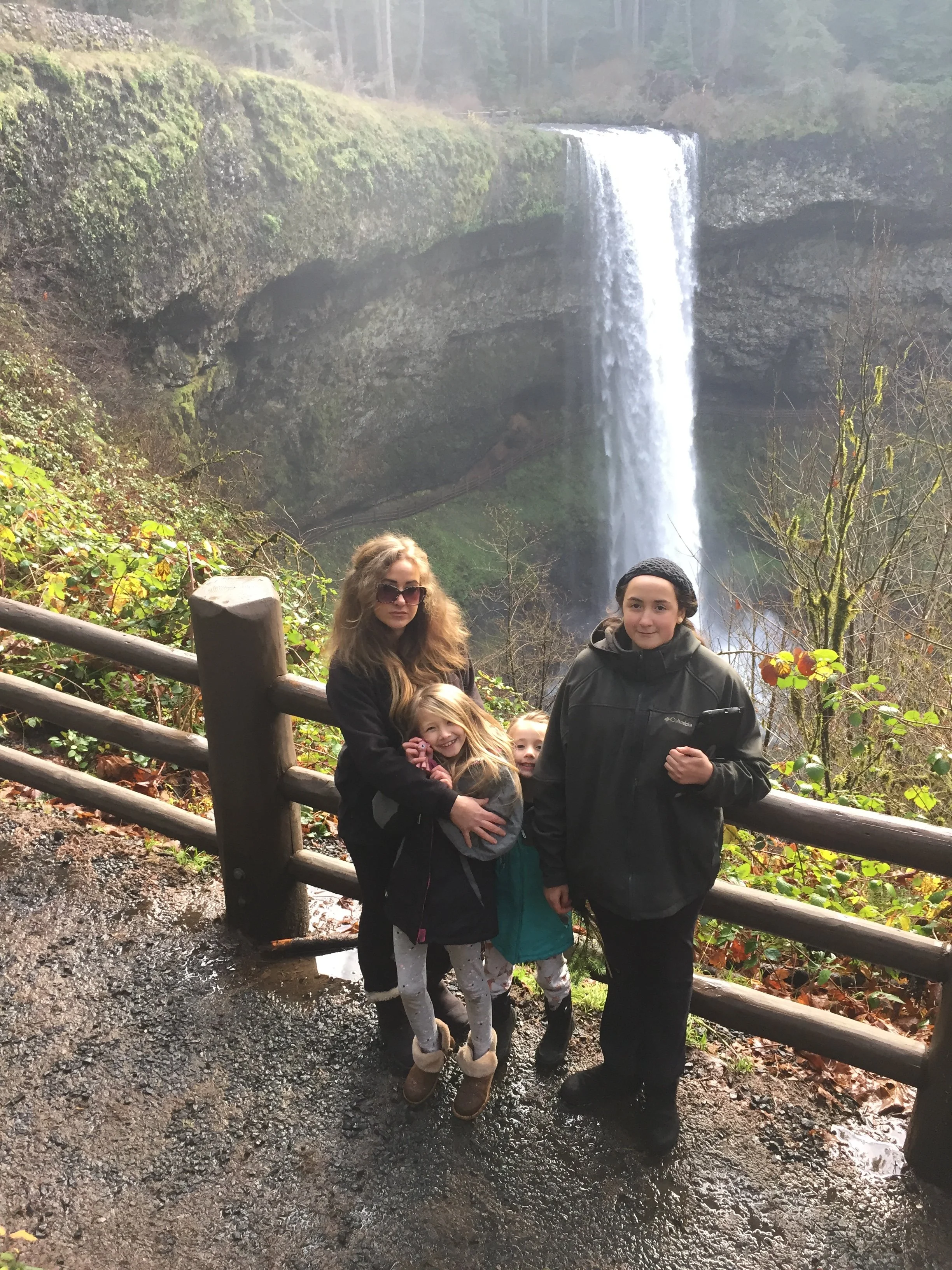 The Bellrose family in front of a waterfall in Oregon during their full-time road years — the journey that led to Elev8150