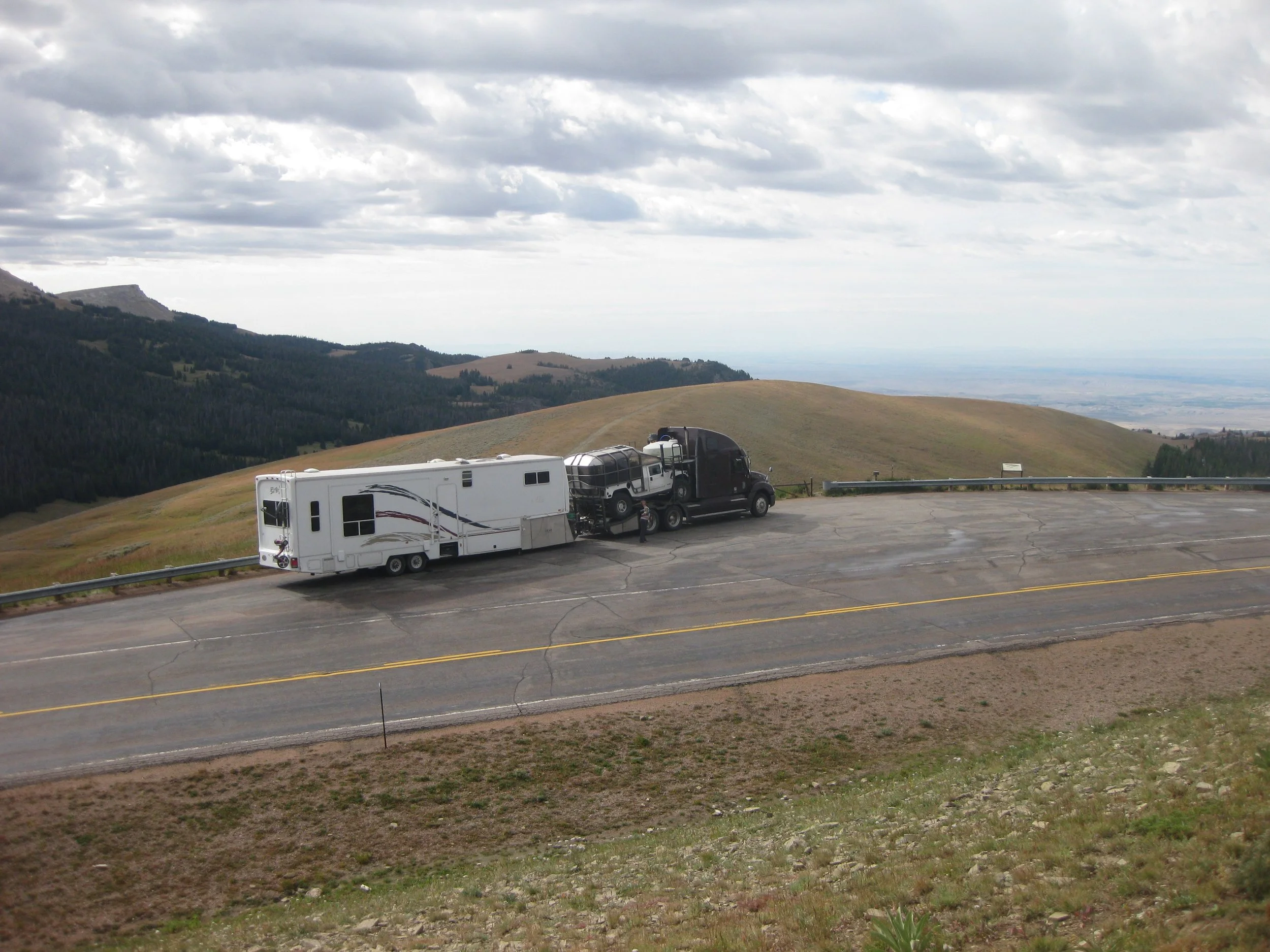 Columbia Freightliner with custom bed carrying a custom tour Hummer pulling the original Bellrose 5th wheel through upper Wyoming heading to Red Lodge Montana — early years of Elev8150 road life